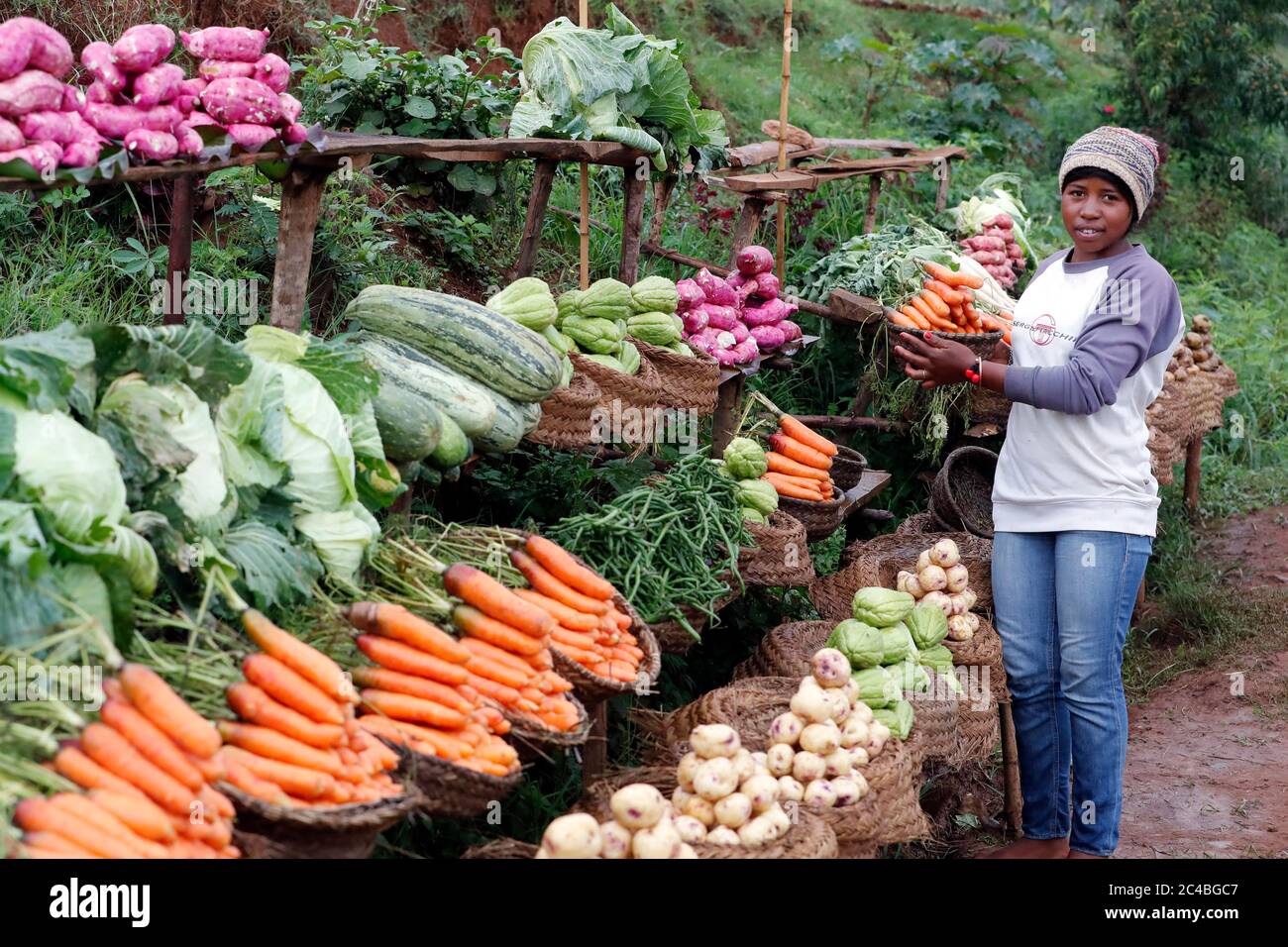 Woman selling fresh vegetables at market Stock Photo