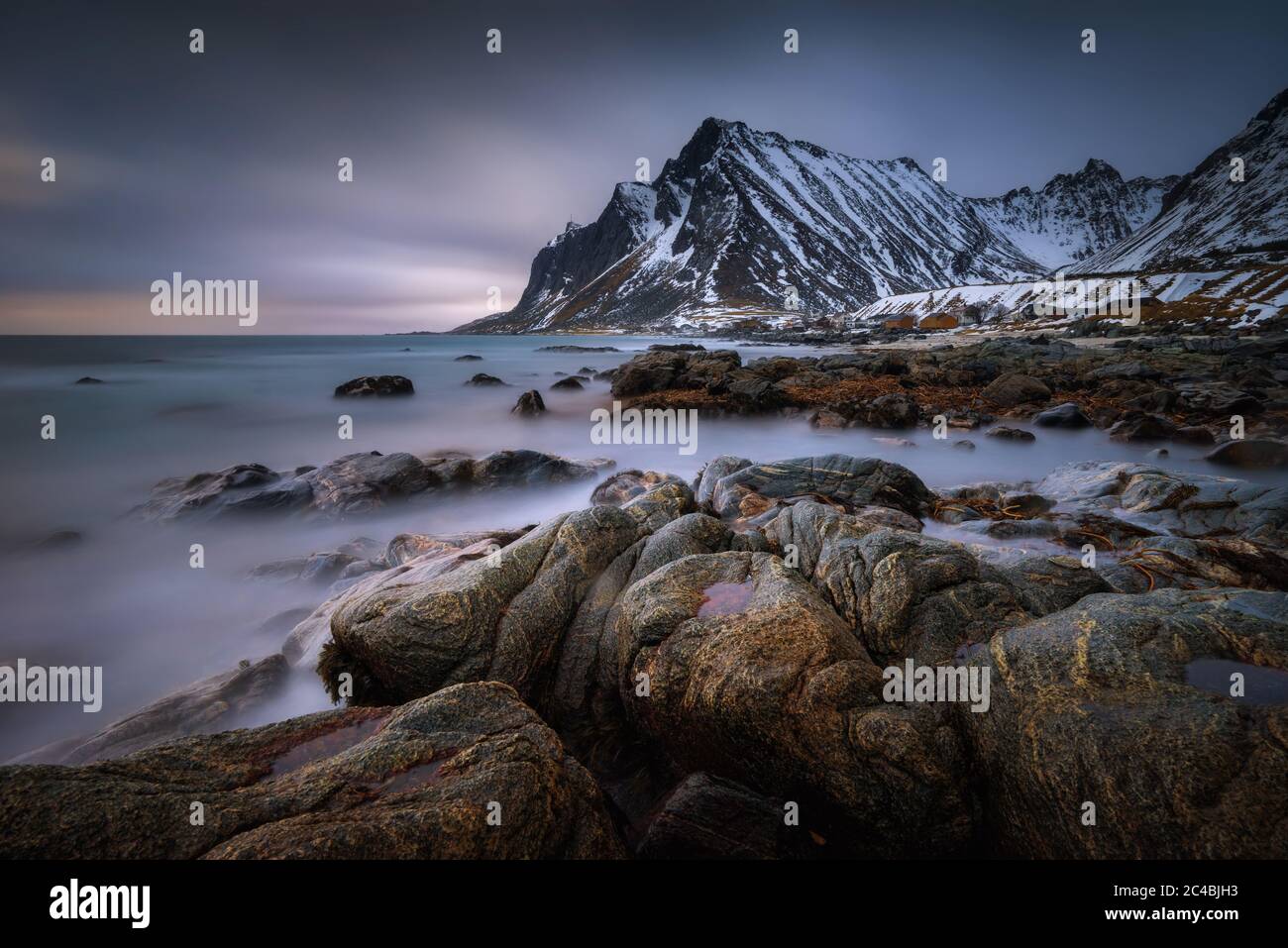 Vikten village coastline with snowy mountains in background, Norway Stock Photo