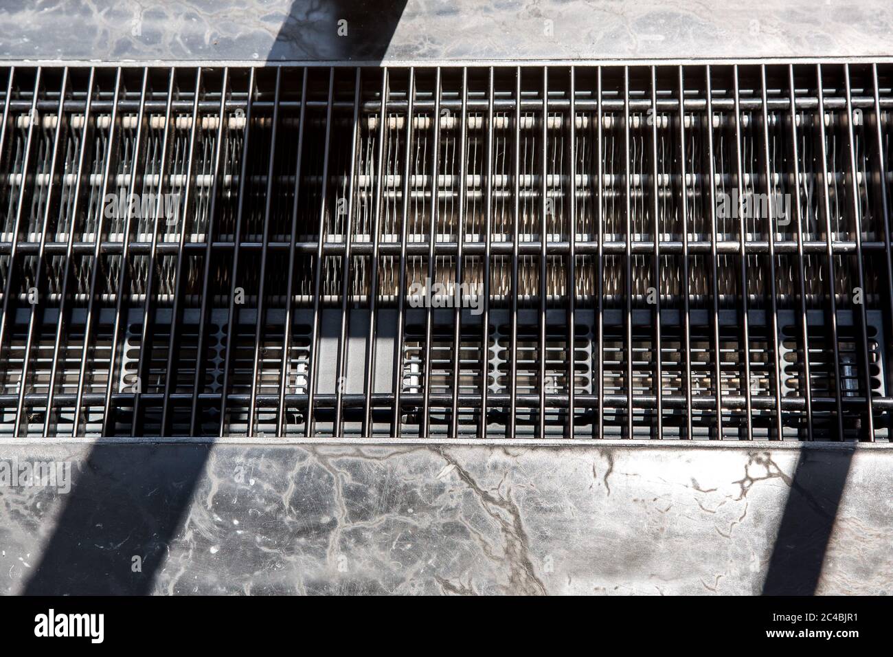 air conditioning system built into the floor to create a climate in the room, close up of the protective grid in the surface of the stone floor. Stock Photo