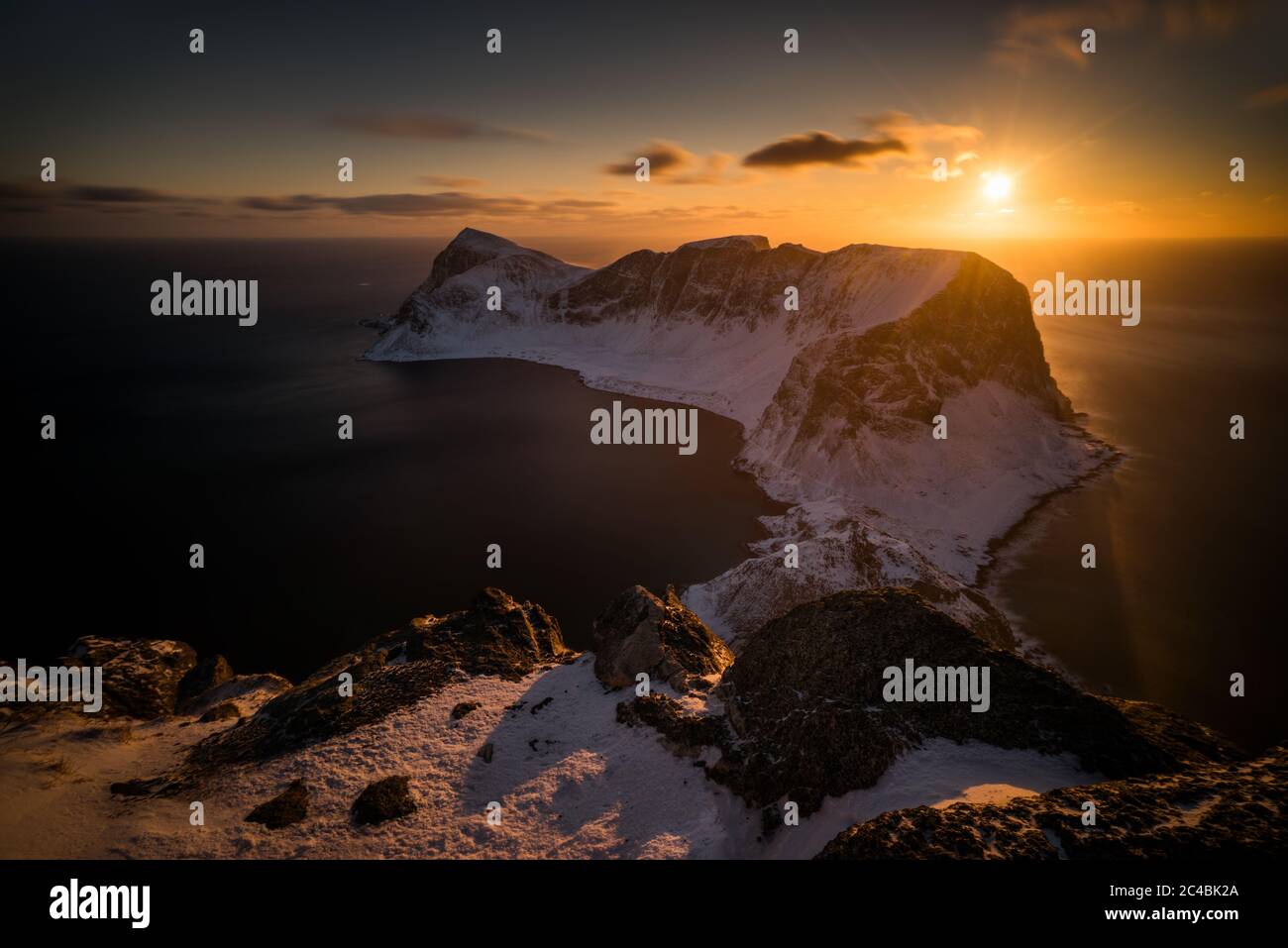 Mountain ridge of Vaeroy island at snowy winter in sunset, Lofoten Stock Photo