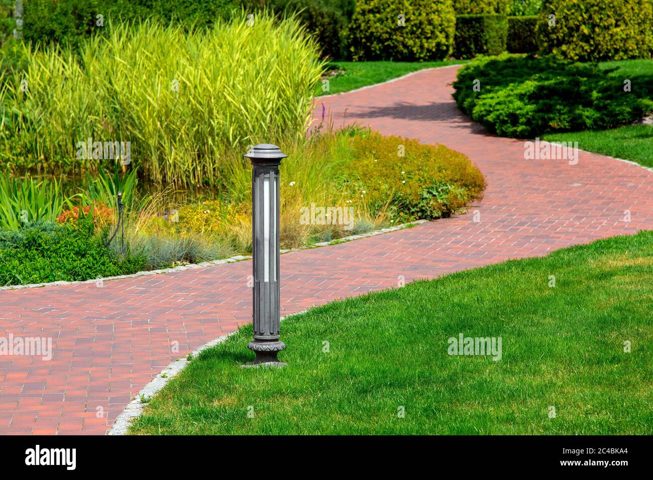 Lighting ground lamp street mounted on a green lawn in a park with
