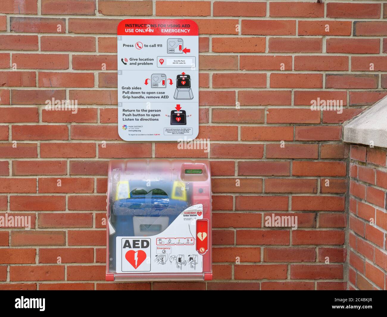 Automated external defibrillator and instructions on brick wall. Scoville Park, Oak Park, Illinois. Stock Photo