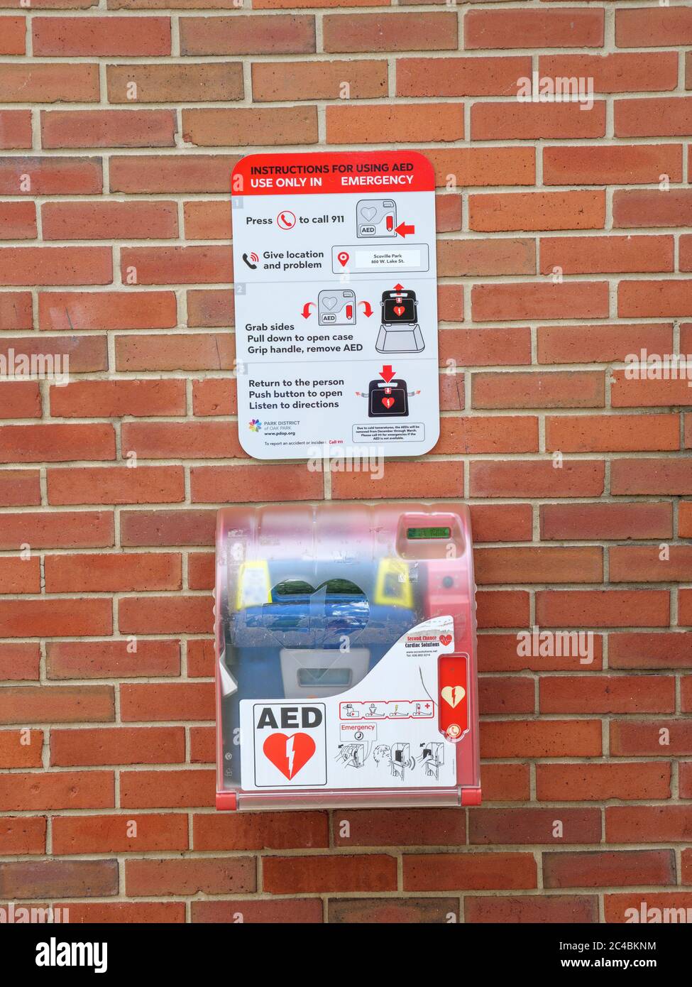 Automated external defibrillator and instructions on brick wall. Scoville Park, Oak Park, Illinois. Stock Photo