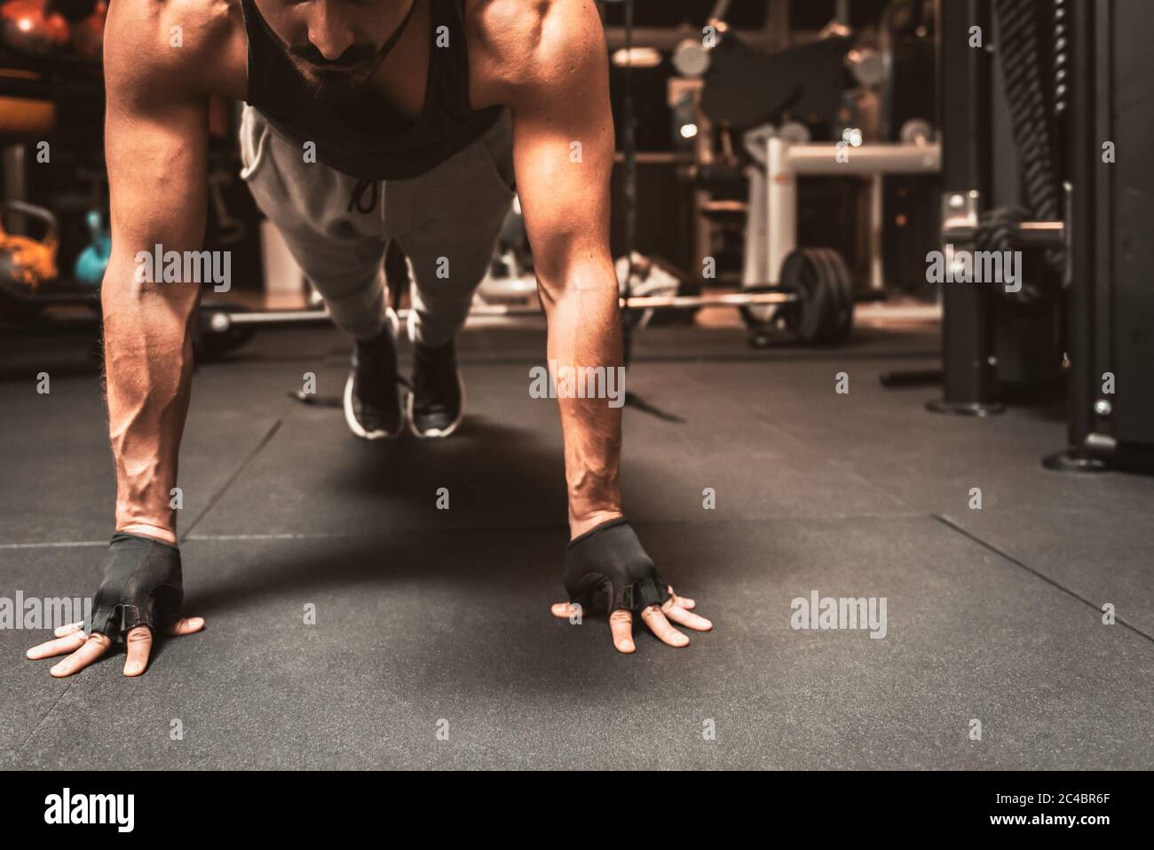 A sporty man in the gym is doing yoga exercises, practicing standing in