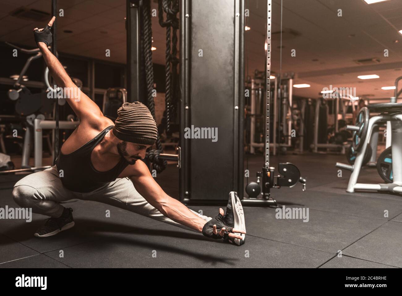 A bearded sporty man in the gym is doing Yoga and Martial Arts