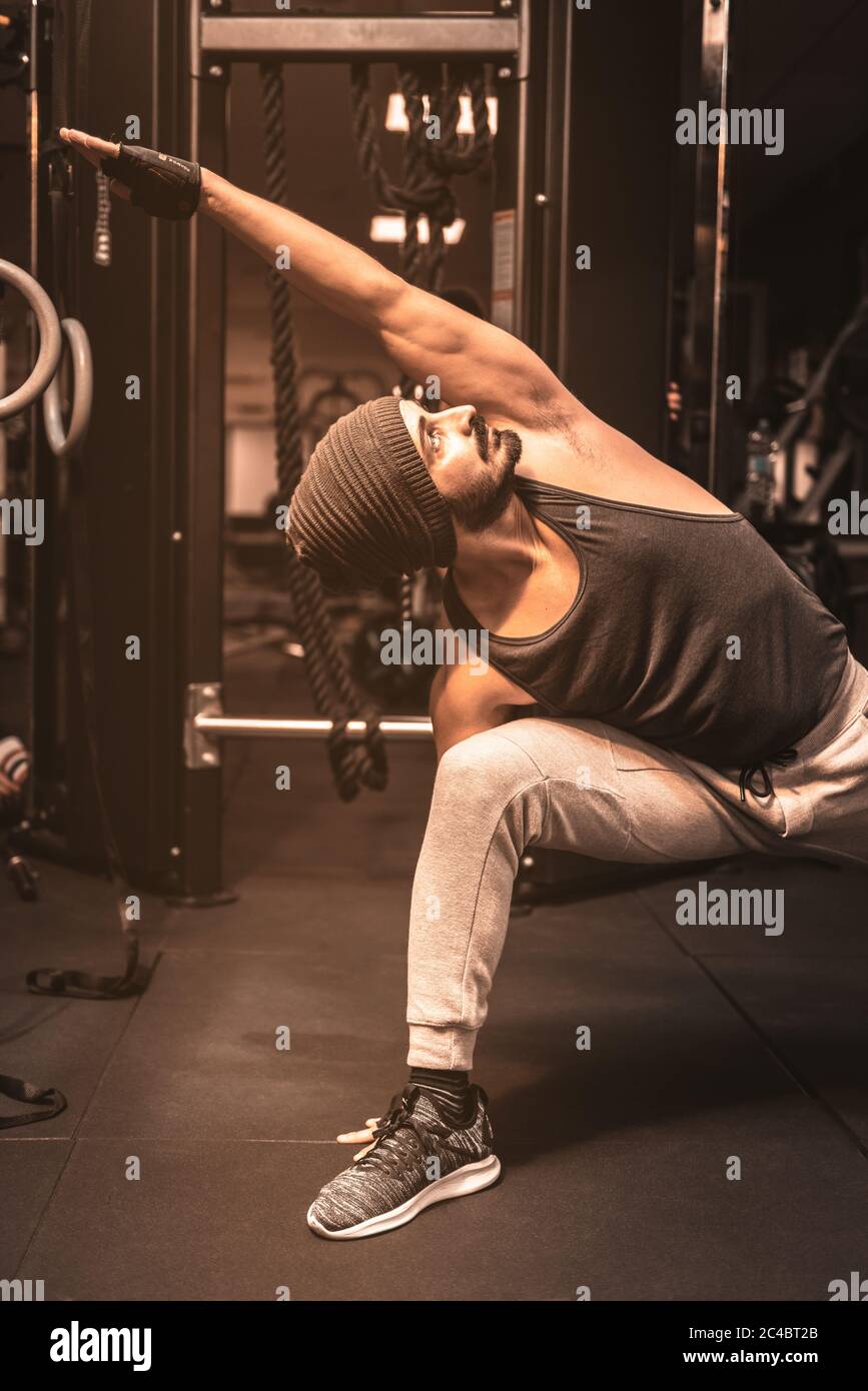 A bearded sporty man in the gym is doing Yoga and Martial Arts exercises.  Fierce Warrior Pose Yoga Sequence. Utthita Parsvakonasana Yoga Position  Stock Photo - Alamy