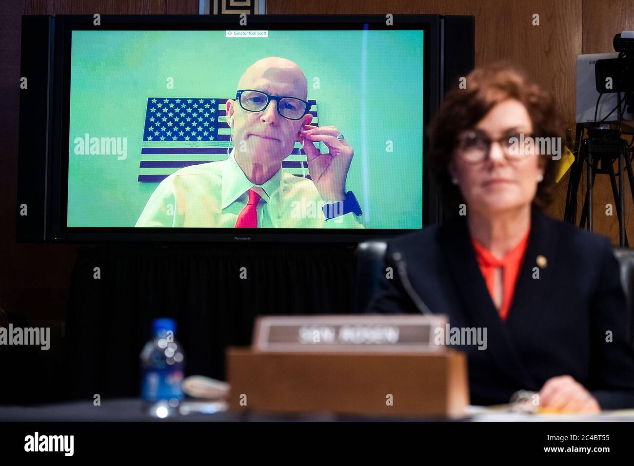 United States Senator Rick Scott (Republican of Florida), participating remotely, directs a question to Mark A. Morgan, acting commissioner of the U.S. Customs and Border Protection, during the US Senate Homeland Security and Governmental Affairs Committee hearing titled 'CBP Oversight: Examining the Evolving Challenges Facing the Agency,' in Dirksen Senate Office Building on Thursday, June 25, 2020. United States Senator Jacky Rosen (Democrat of Nevada), appears at right. Credit: Tom Williams/Pool via CNP /MediaPunch Stock Photo