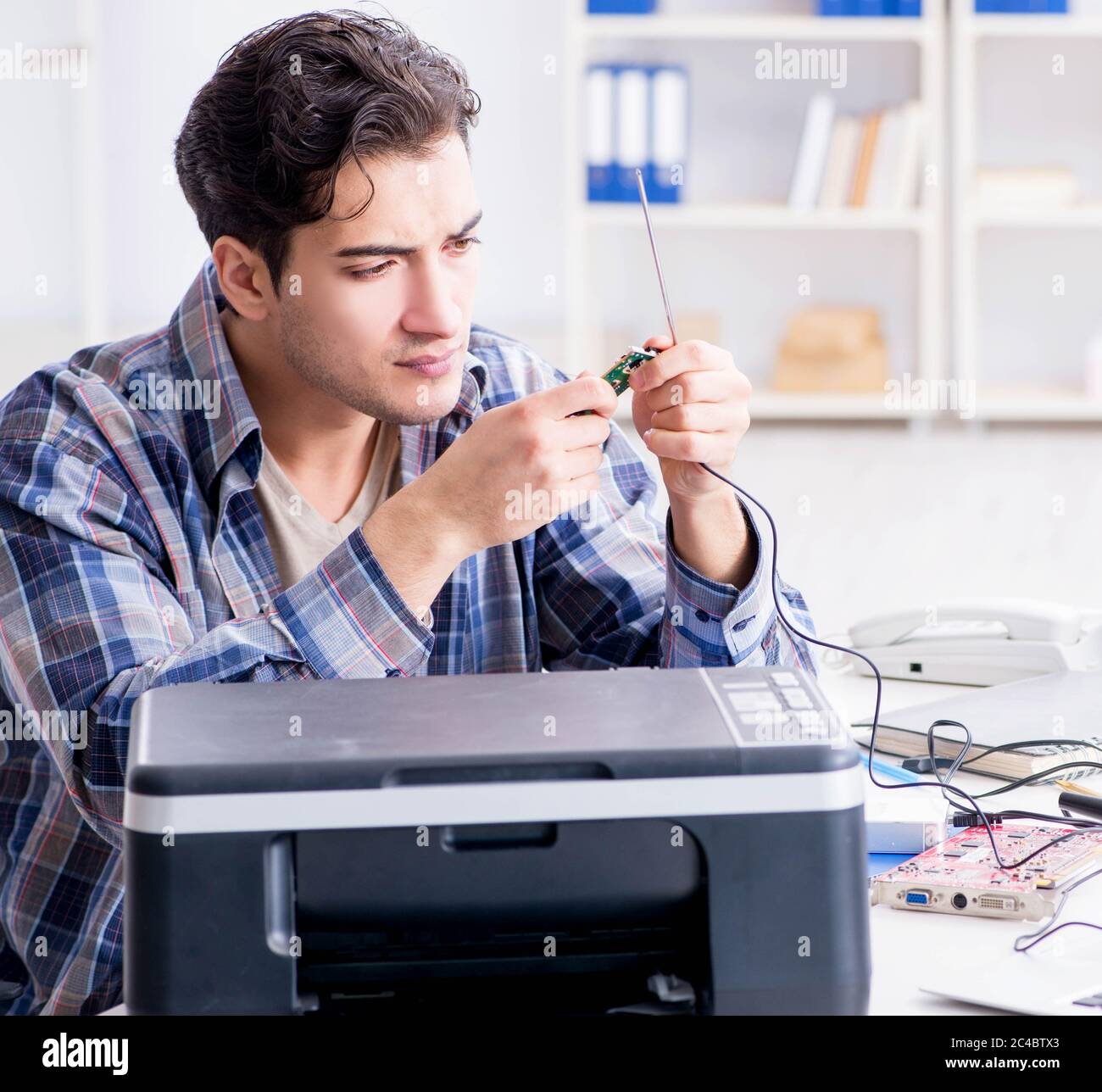The hardware repairman repairing broken printer fax machine Stock Photo