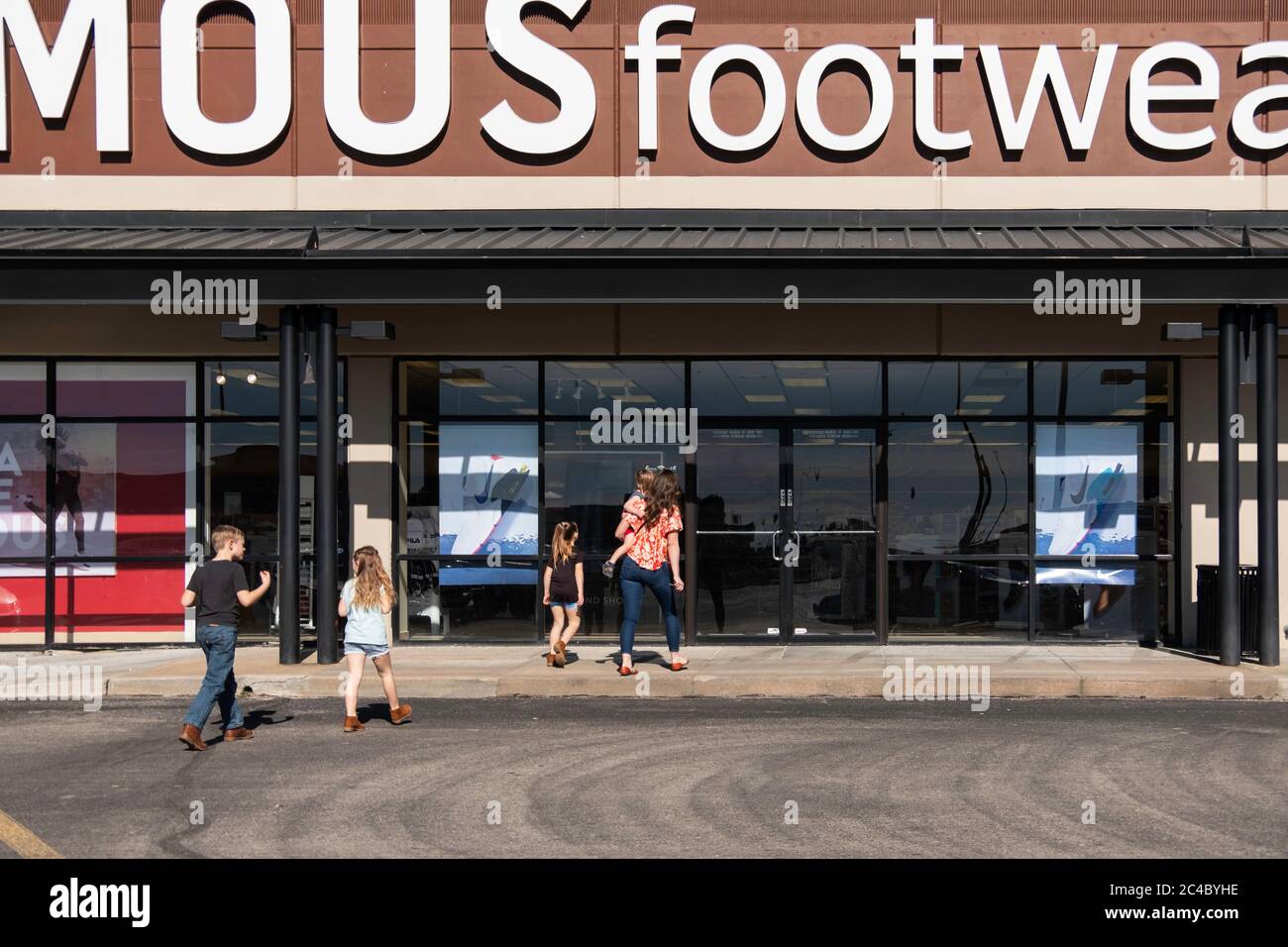 A woman and four children enter a Famous Footwear store. Wichita, Kansas, USA. Stock Photo