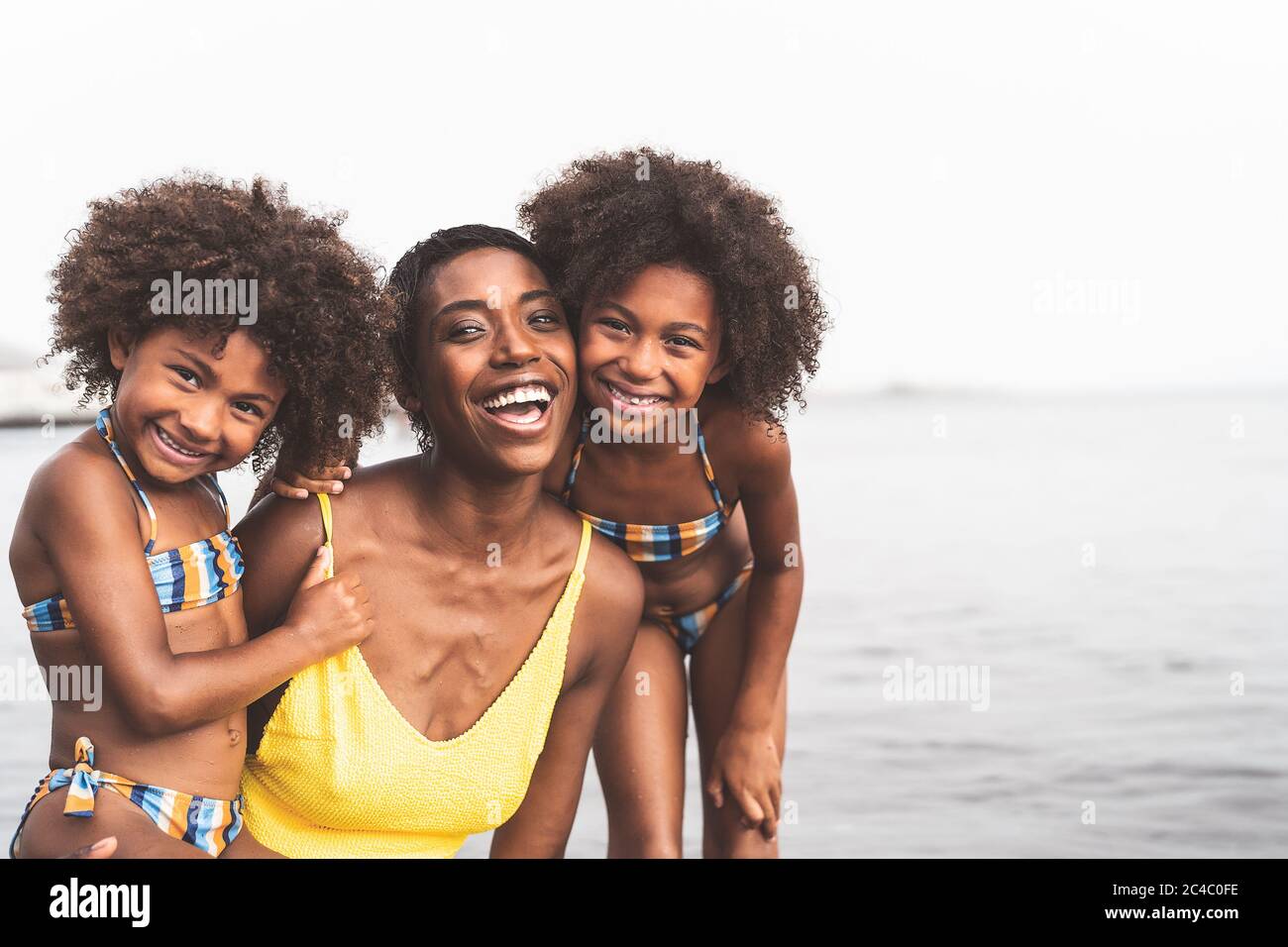 Happy African family on the beach during summer holidays Afro