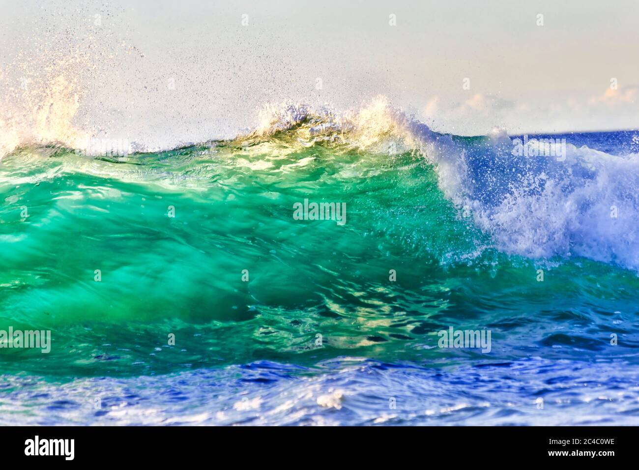 Half wave swirling and rolling to Northern Sydney beach at sunrise - stormy Pacific ocean. Stock Photo