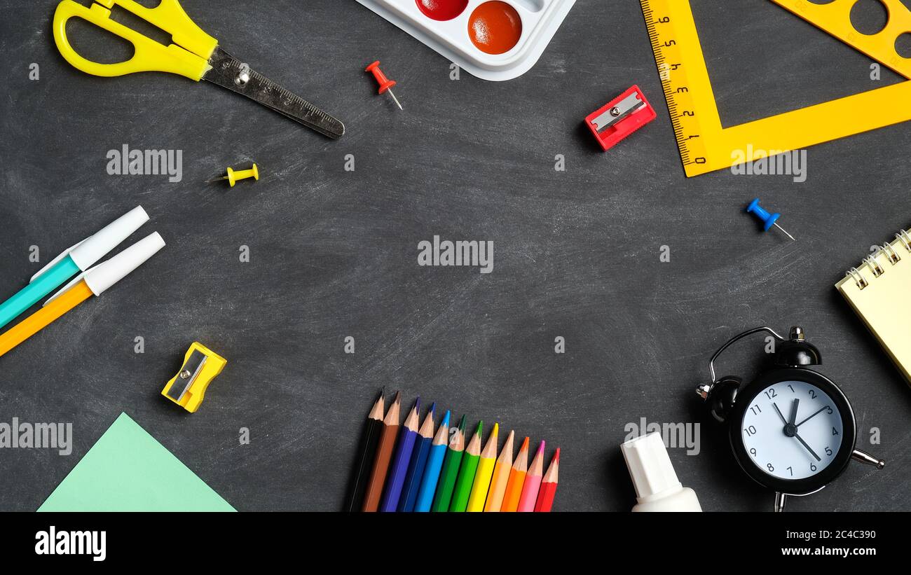 Back to school concept. Frame of school supplies on a black board ...