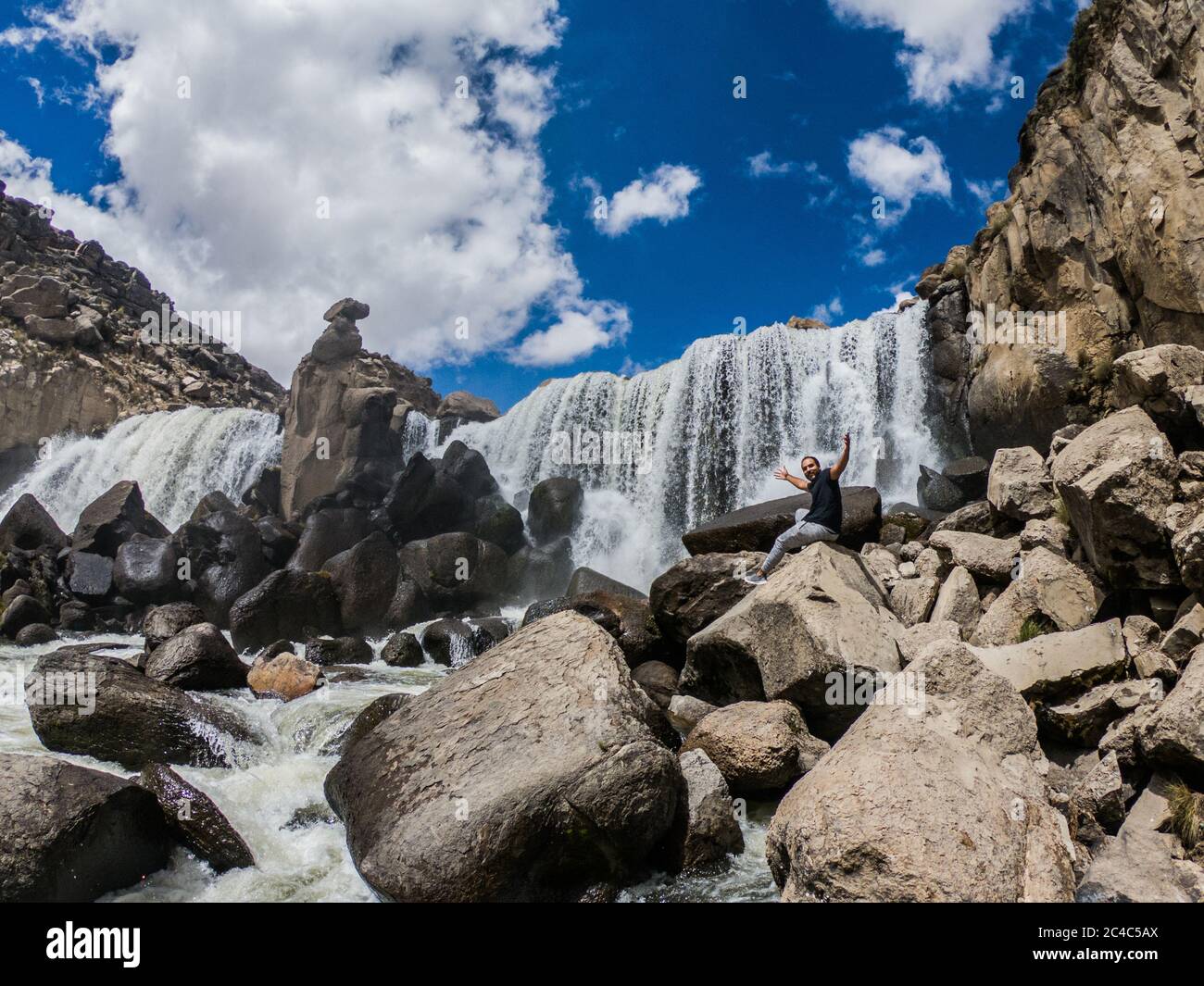 big waterfall and a lot of rocks, clouds and blue sky Stock Photo