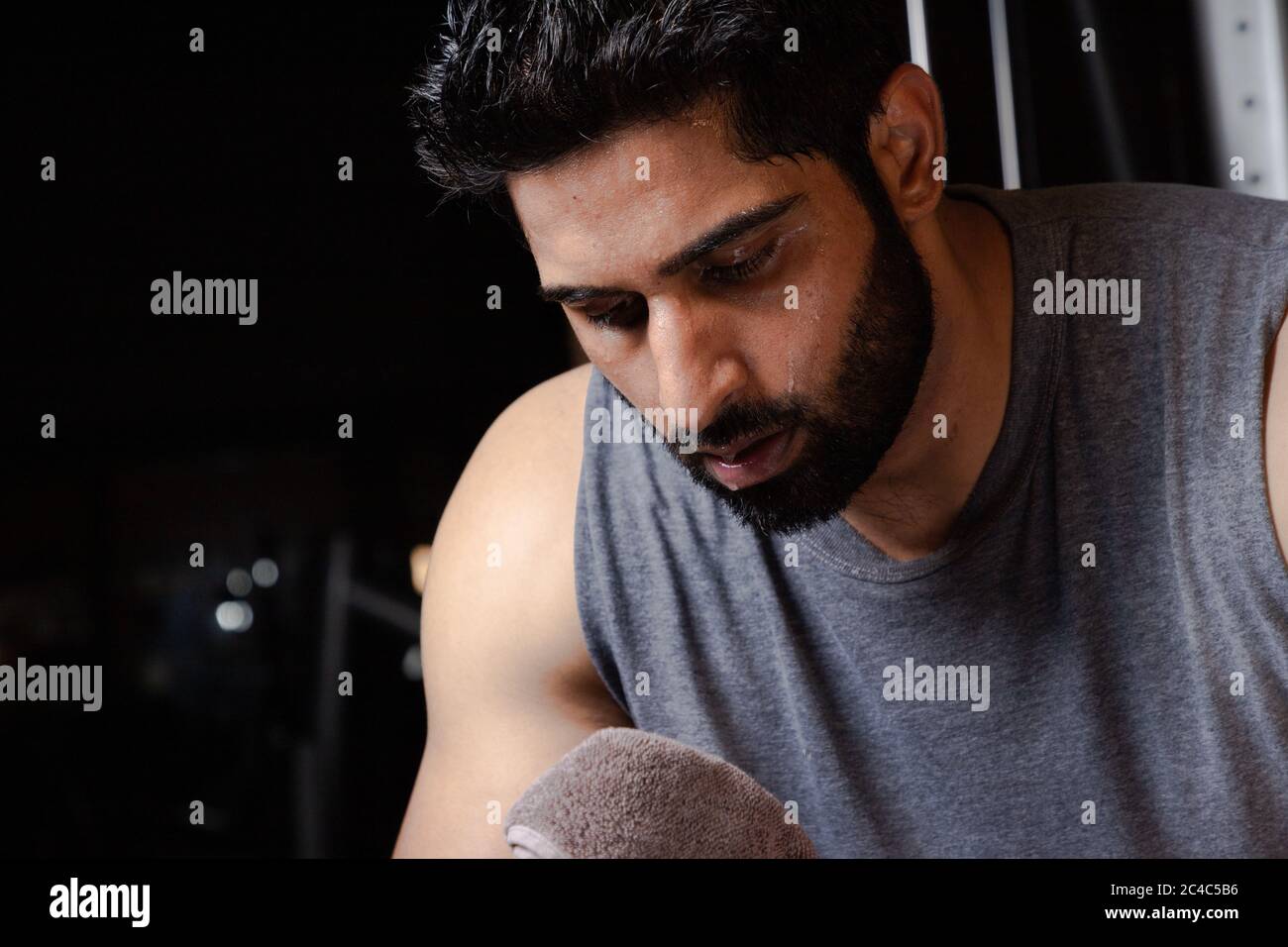 closeup of Beard man cleaning sweat with towel after workout ,Man tired after workout in full Sweating Stock Photo