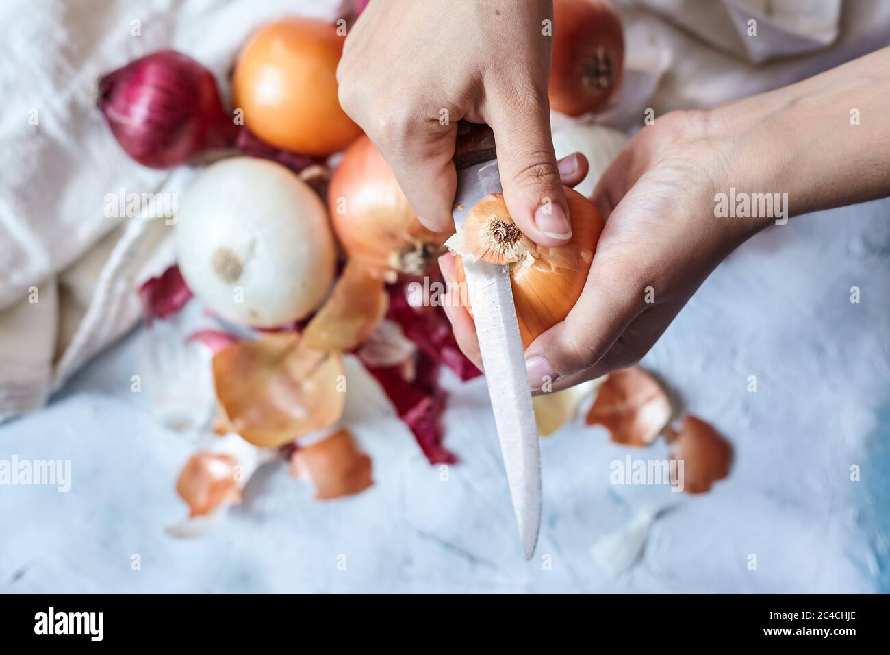 Cleaning fresh onions in the kitchen. Top view Stock Photo - Alamy