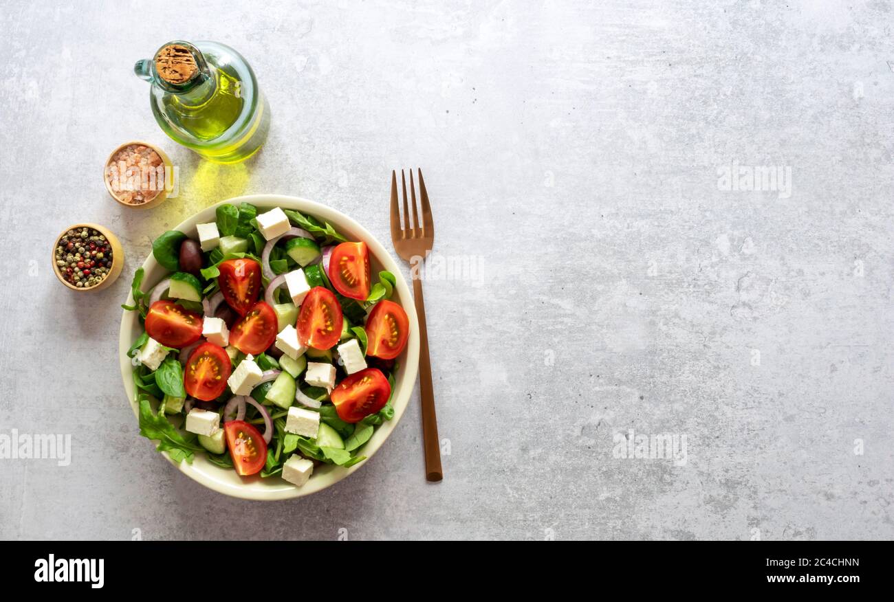 Greek salad of fresh cucumber, tomato, lettuce, red onion, feta cheese, and kalamata olives.  Stock Photo