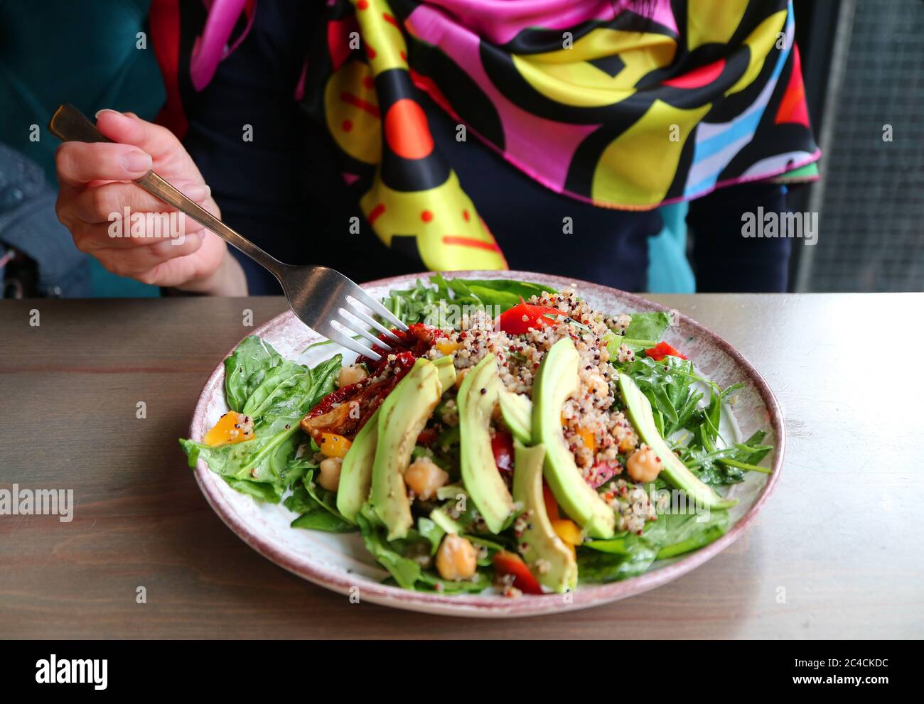 Female Eating Healthy Meal of Quinoa Salad with Avocado and Arugula Stock Photo