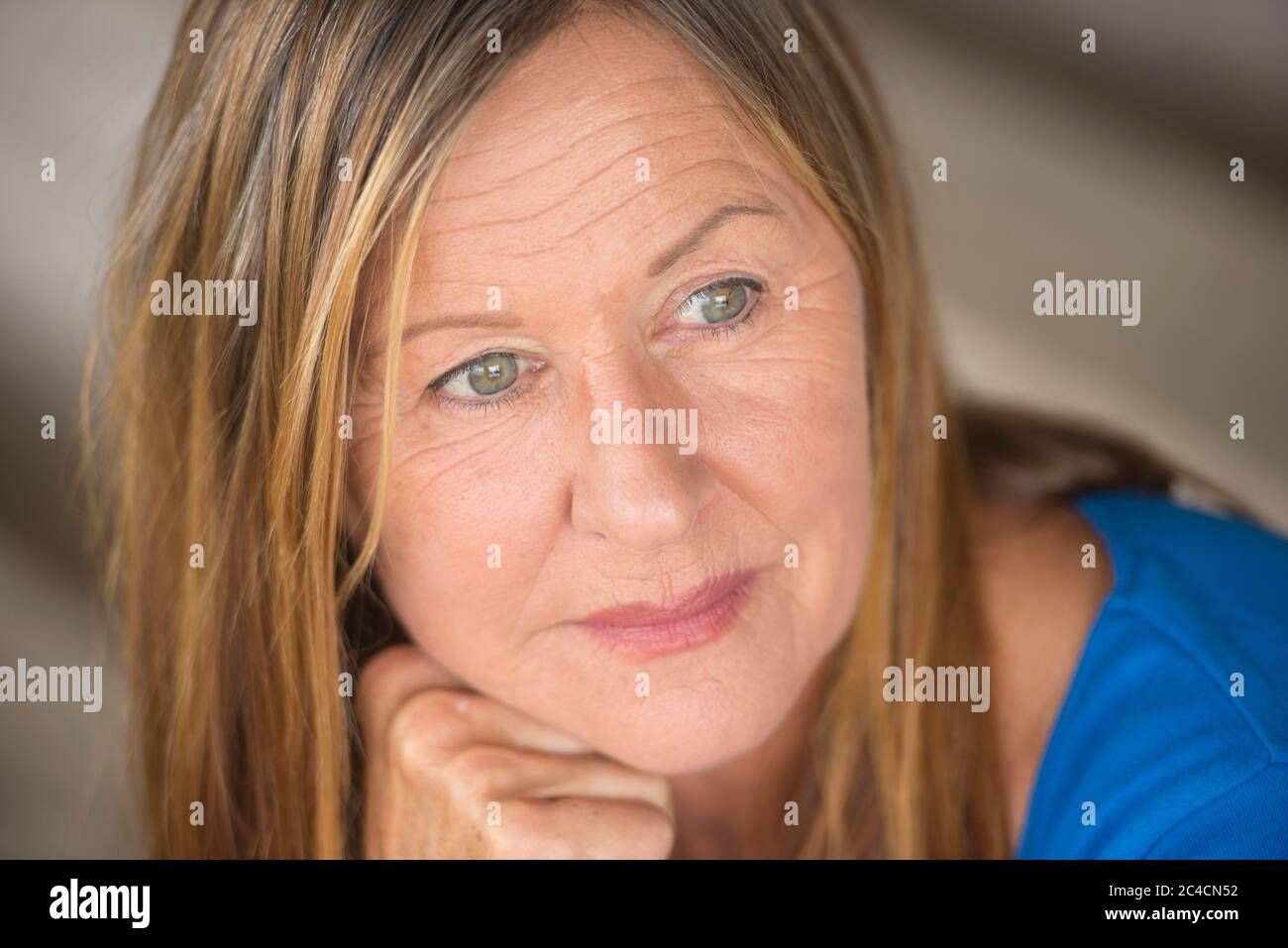 Portrait attractive mature woman with thoughtful serious facial expression, relaxed, confident, blurred background. Stock Photo