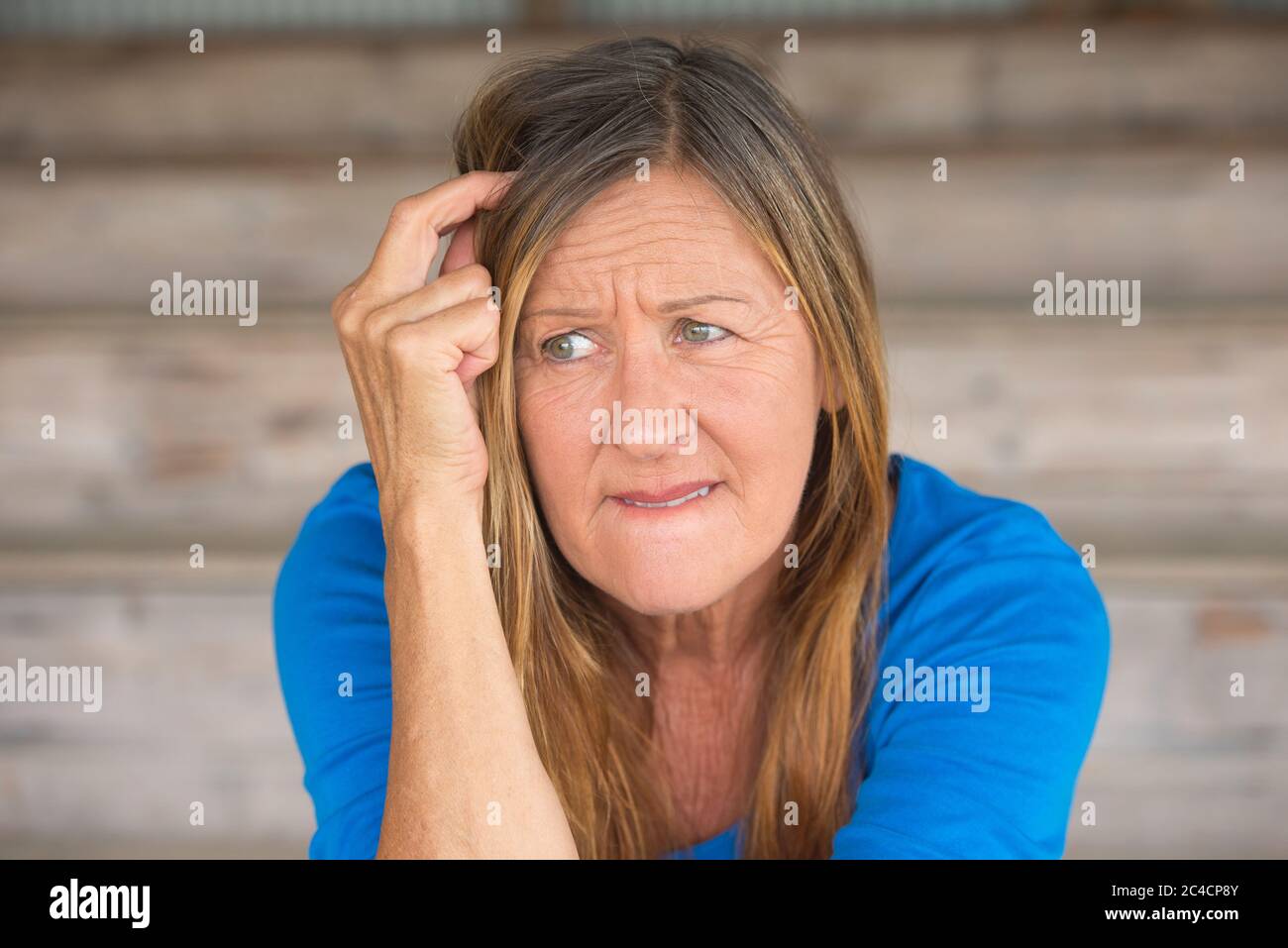 Portrait attractive mature woman with upset thoughtful angry facial expression, lonely worried, blurred background. Stock Photo
