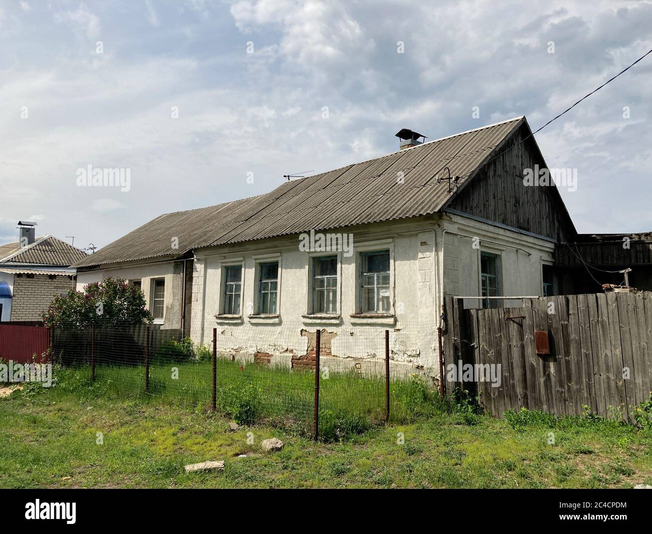 Close up of old houses in countryside. Small one-story houses in village on cloudy day. Stock Photo