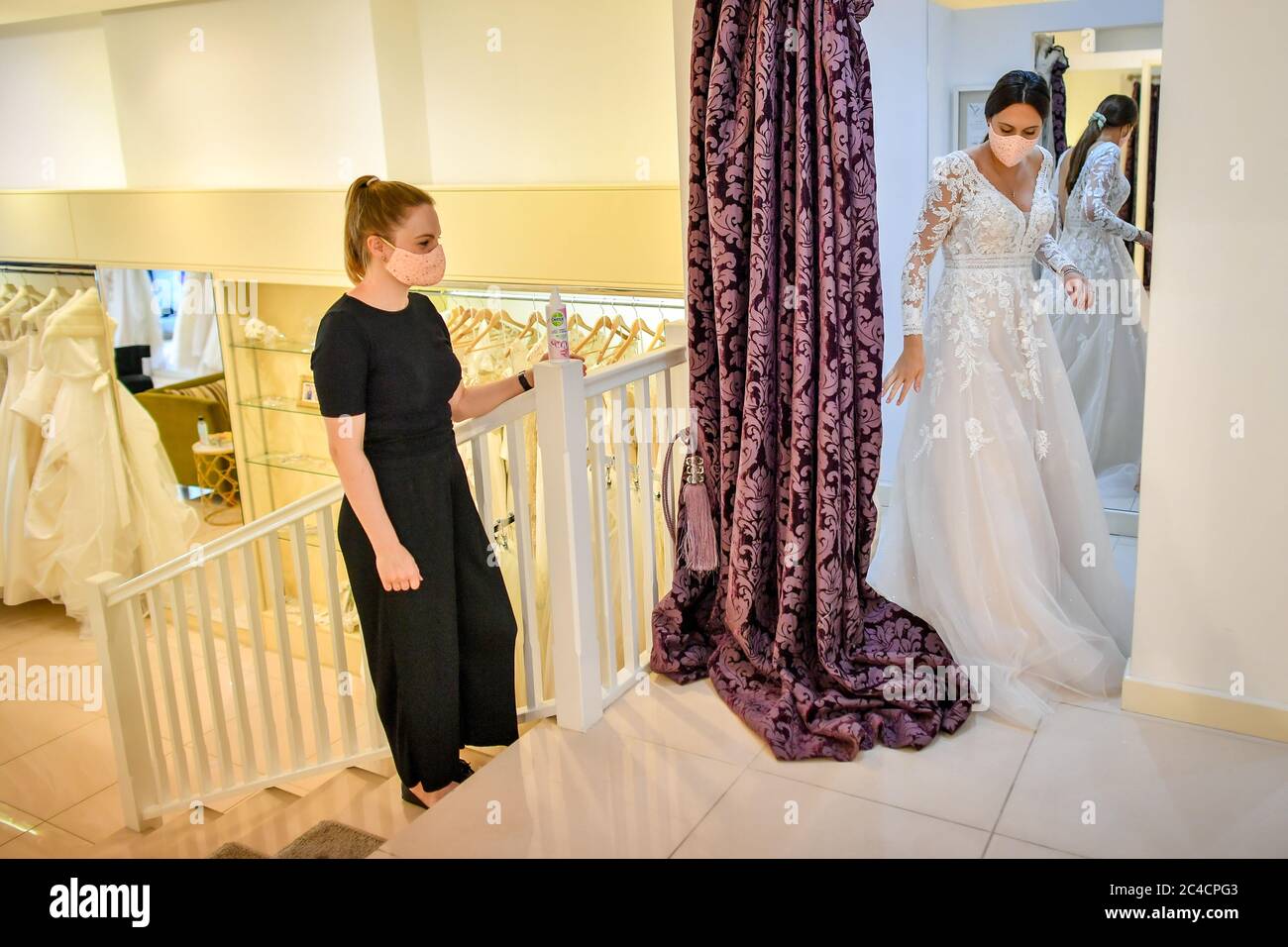 Jessica Letheren exits the fitting room after changing into a wedding dress assisted by bridal consultant Felicity Gray at Allison Jayne Bridalwear in Clifton, Bristol, which has reopened following the lifting of coronavirus lockdown restrictions, with measures put in place to prevent the spread of coronavirus during brides' dress fittings. Stock Photo