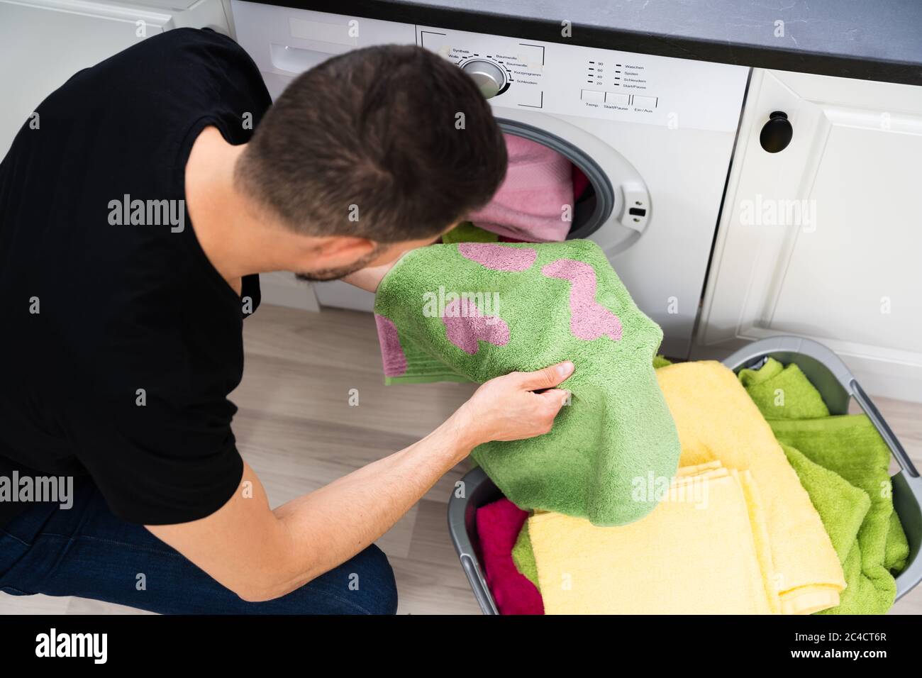 Man Doing Laundry. Stains On Clothes After Washing Machine Stock Photo