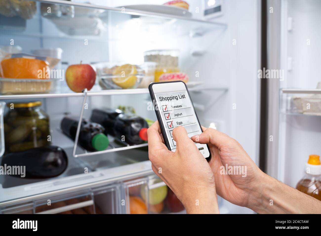 Consumer Grocery Shopping List App And Fridge Stock Photo