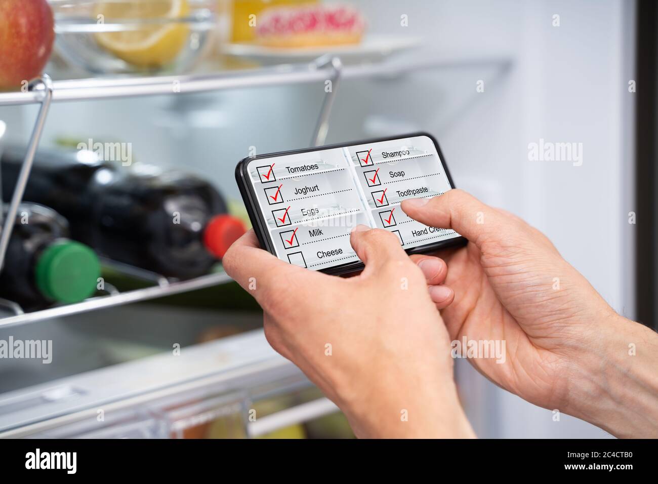 Consumer Grocery Shopping List App And Fridge Stock Photo