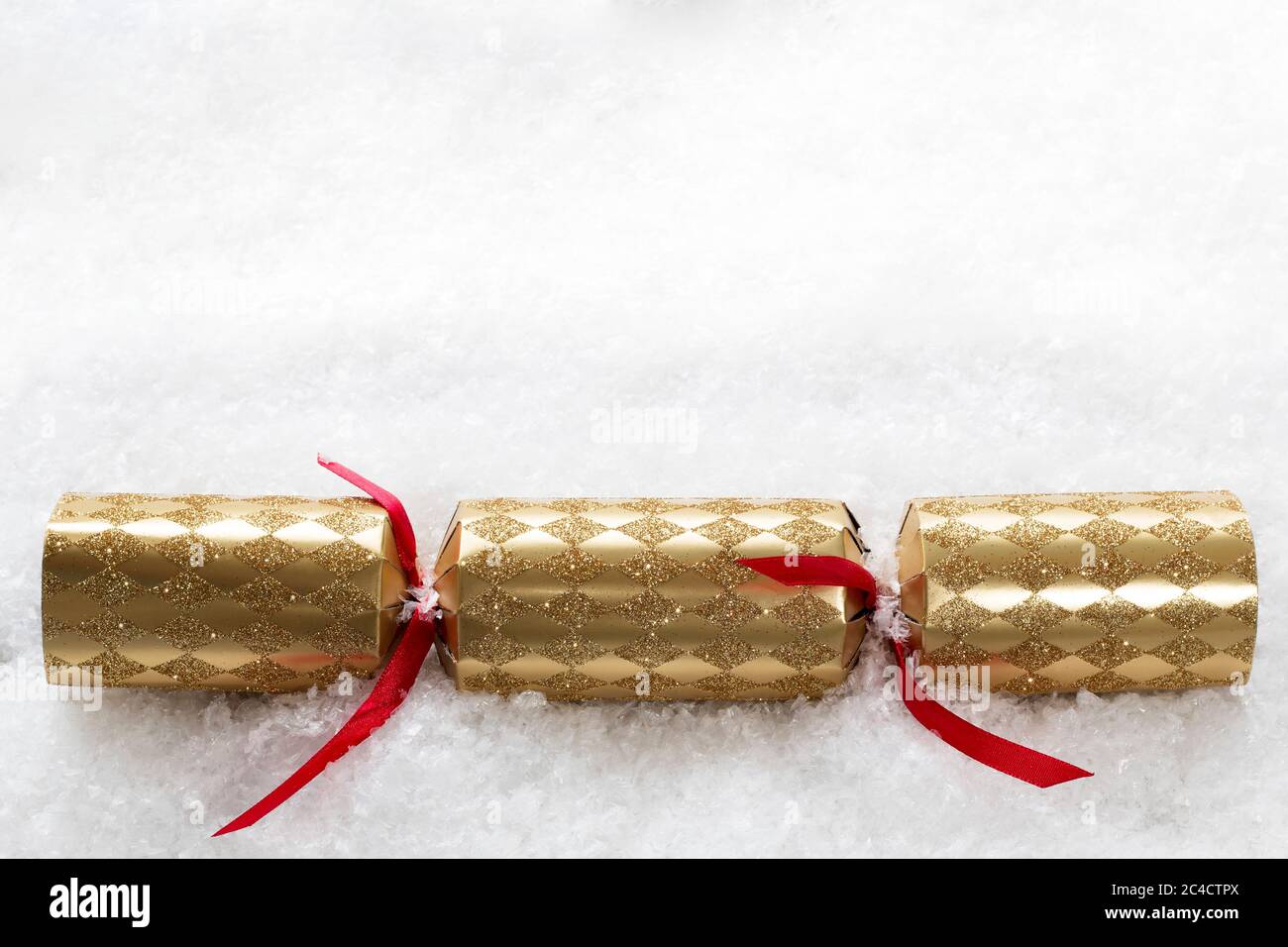Gold Christmas cracker in the snow with copy space for adding your own message Stock Photo
