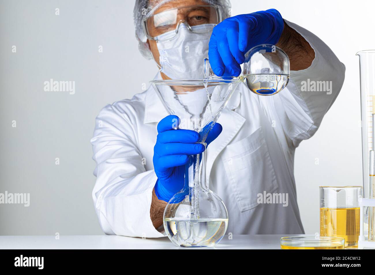 Scientist hands holding some liquid in a glassware in laboratory for ...