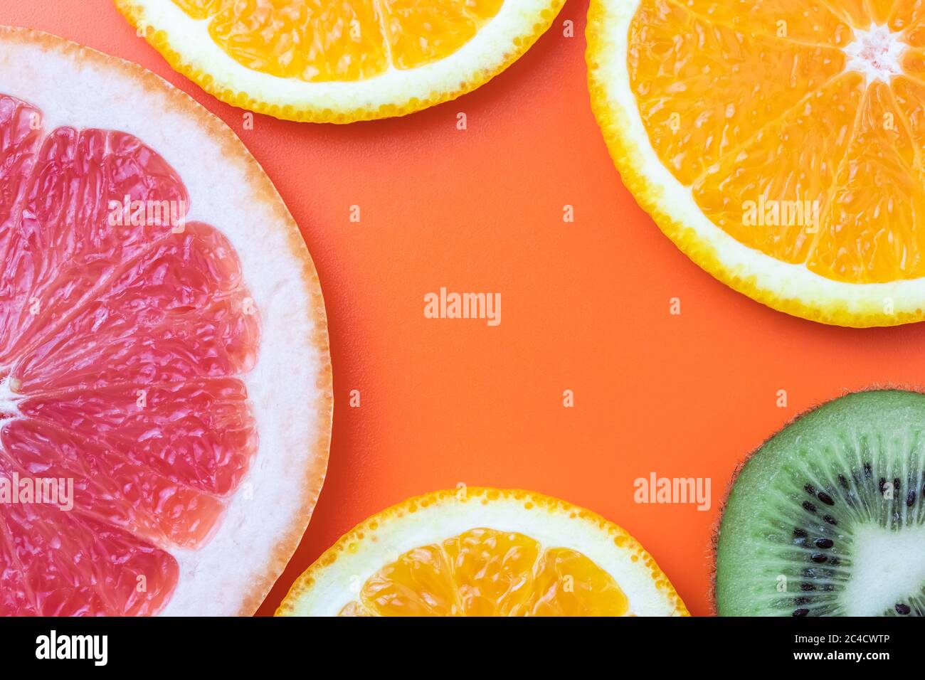 Citrus fruit background, slices of grapefruit, kiwi, mandarin. Summer template with copy space, empty place for text, bright orange wallpaper Stock Photo