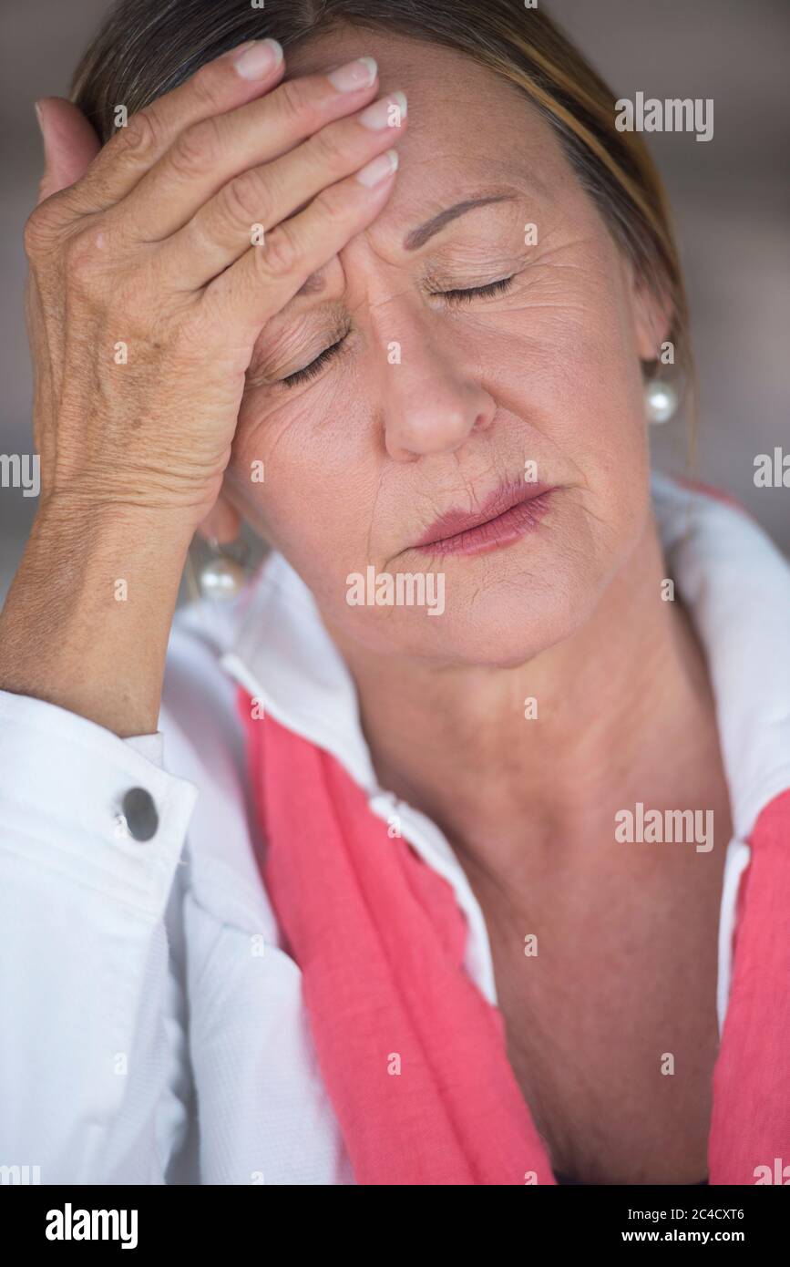 Portrait attractive mature woman with headache, migraine, stressful