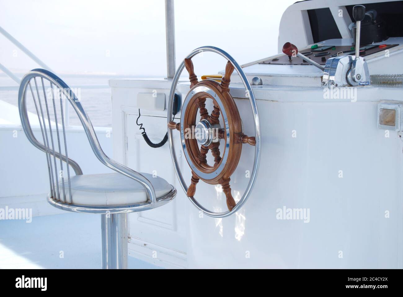 Steering wheel and metal seat on a yacht Stock Photo