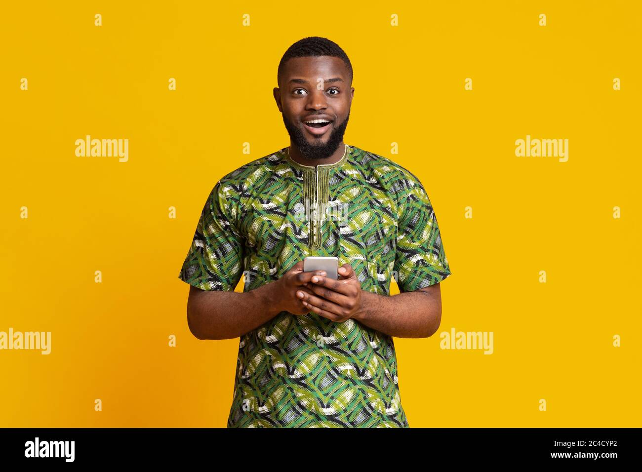 Excited black guy holding modern mobile phone Stock Photo