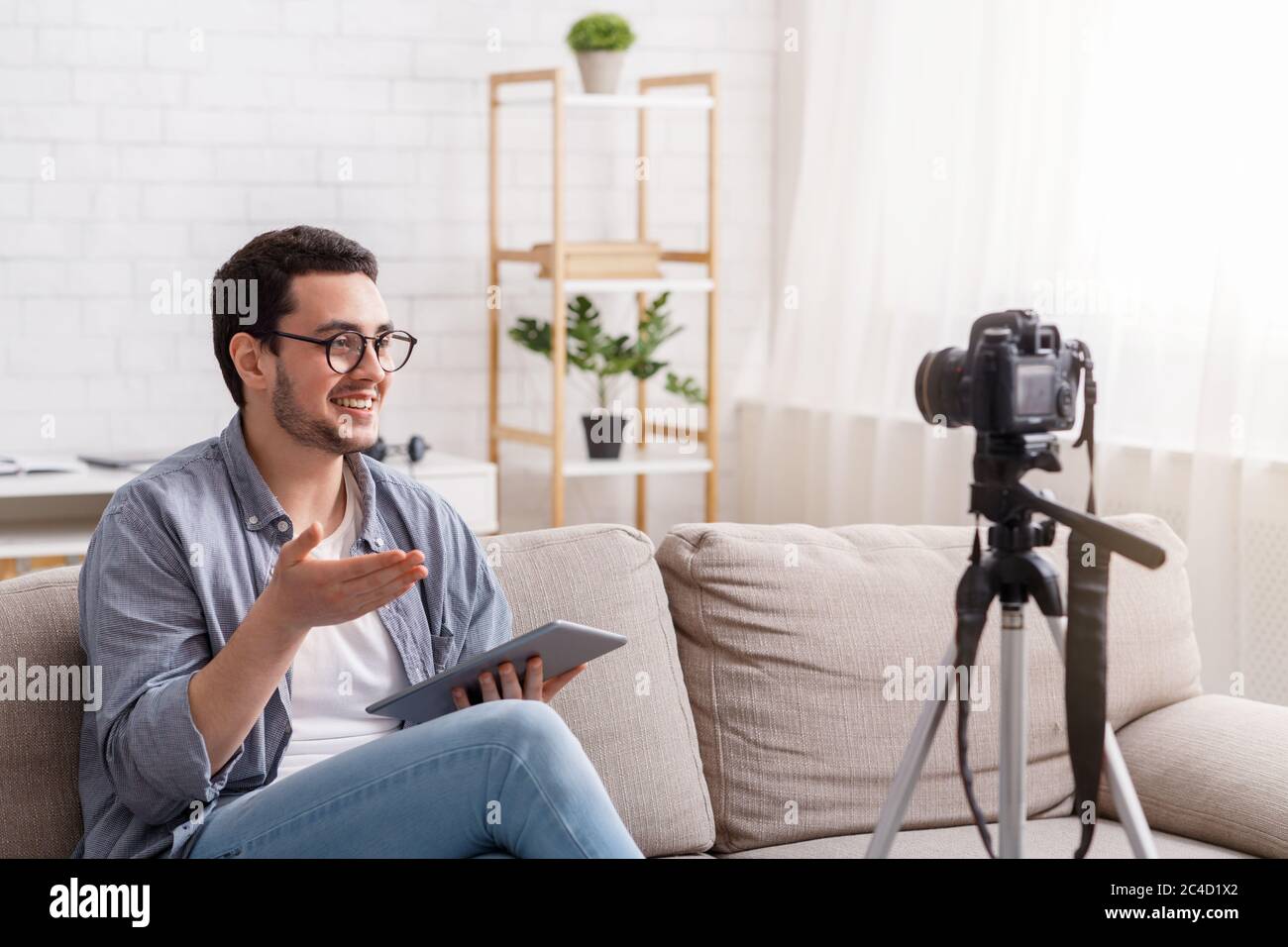 Confident young man recording on camera to blog. Speaking with enthusiasm Stock Photo