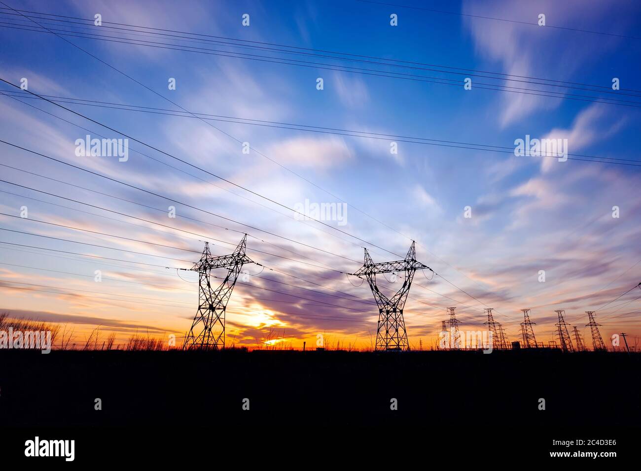 pylon, In the evening, the high voltage tower and the beautiful sunset glow Stock Photo