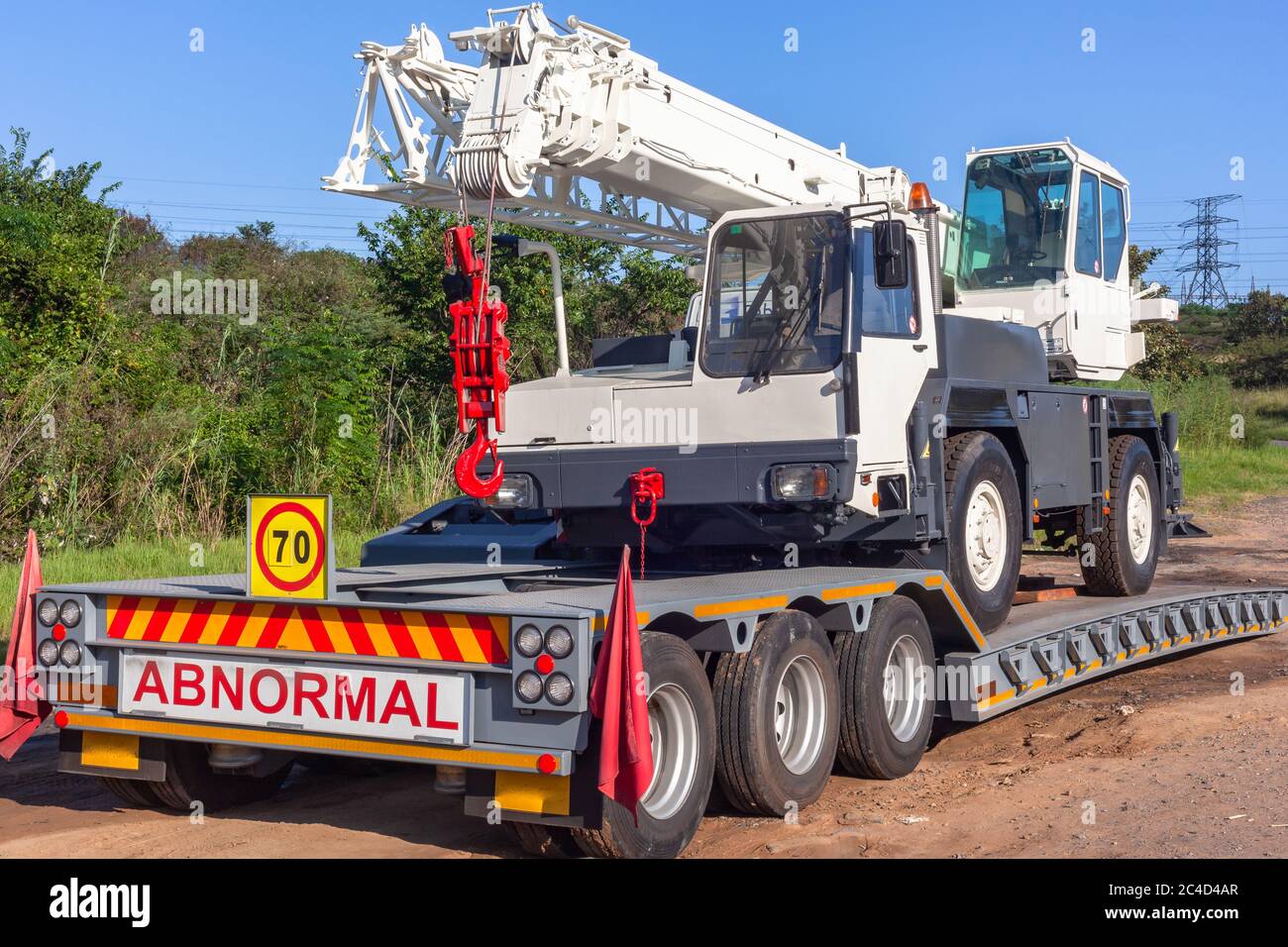 Mobile white crane vehicle for industrial rigging lifting on abnormal  trailer parked roadside closeup photo in blue sky Stock Photo - Alamy
