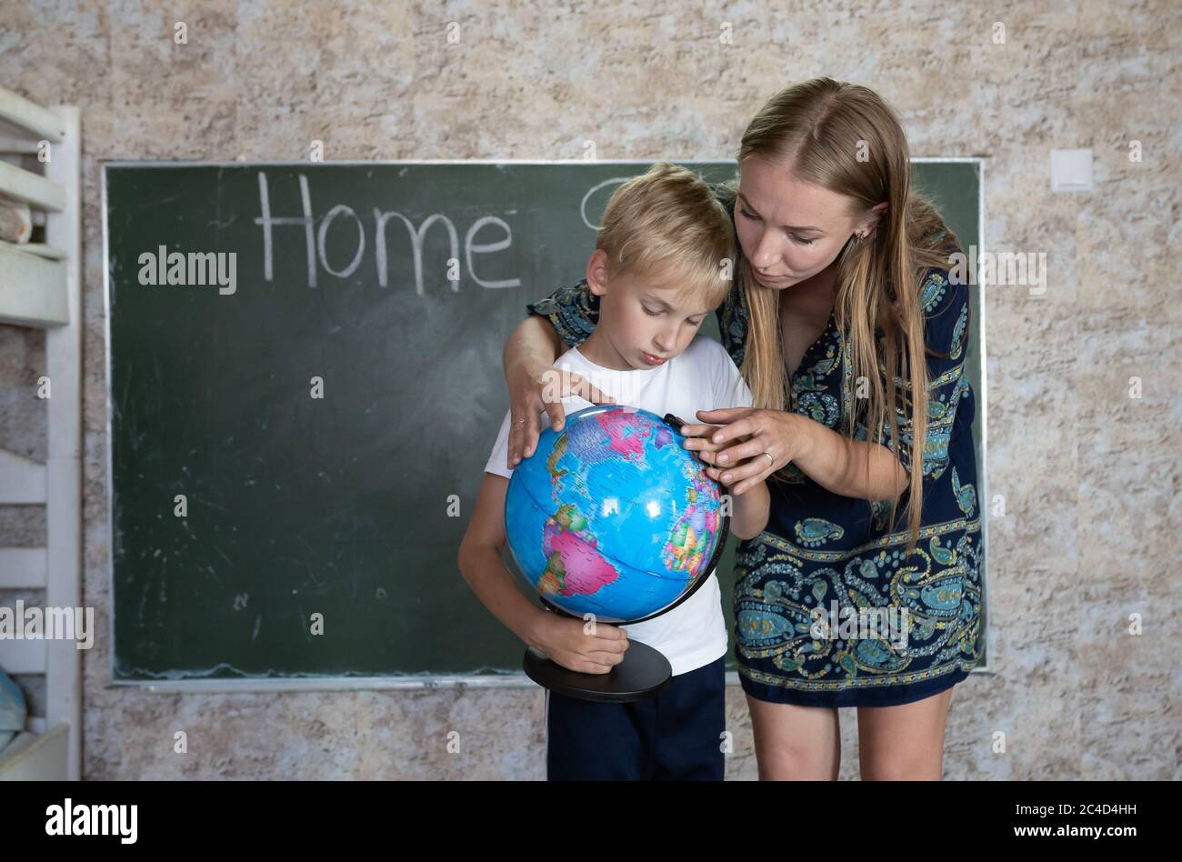 Mother is studying a world map on a globe with her son. Stock Photo