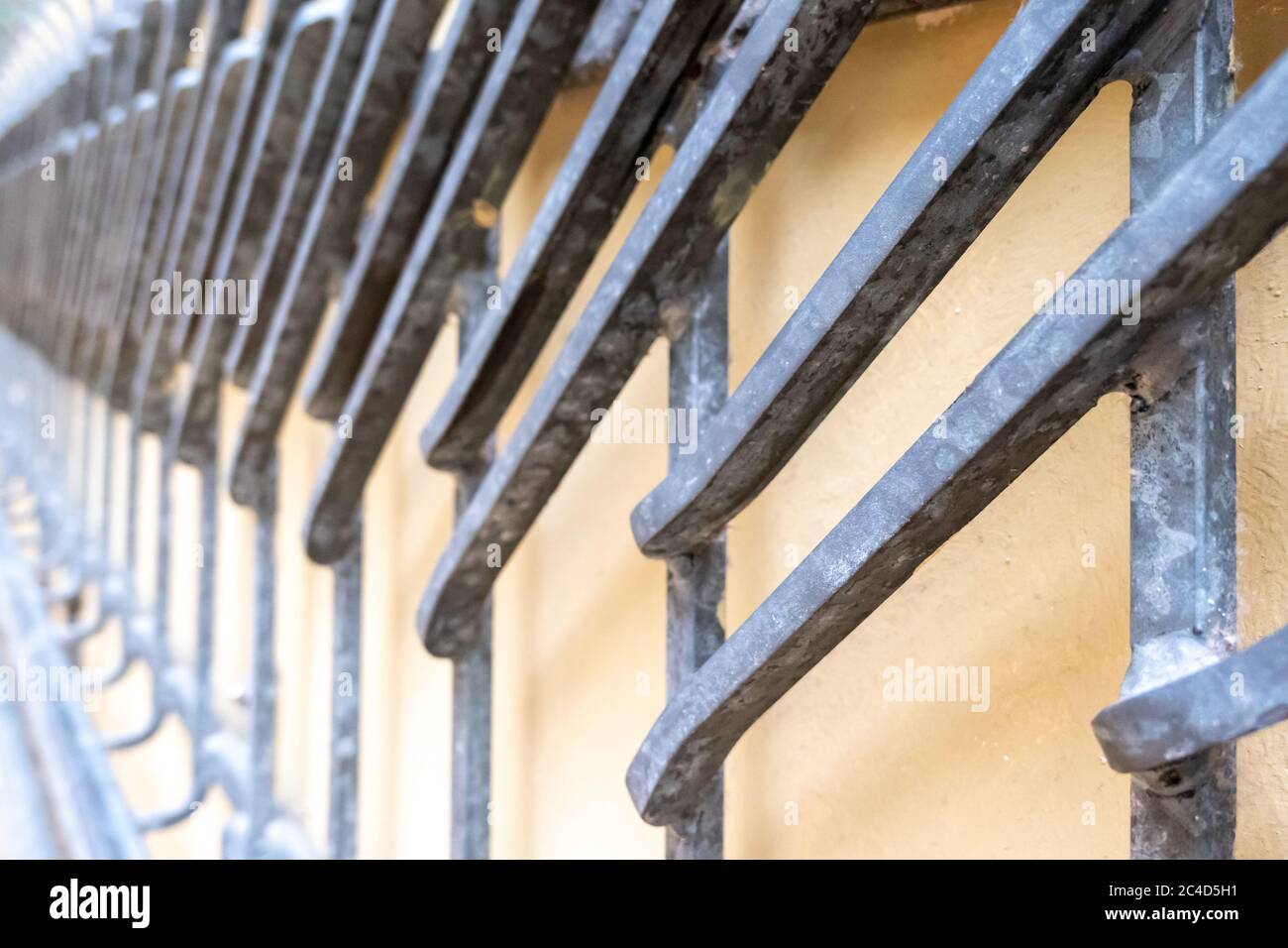 Closeup shot of a rusty metal fence around an old yellow building Stock ...