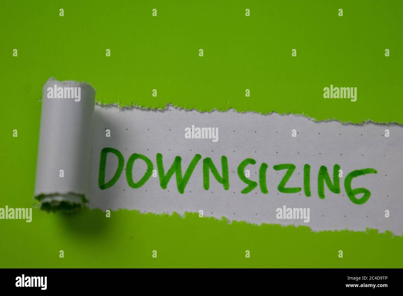 Downsizing Text written in torn paper Stock Photo