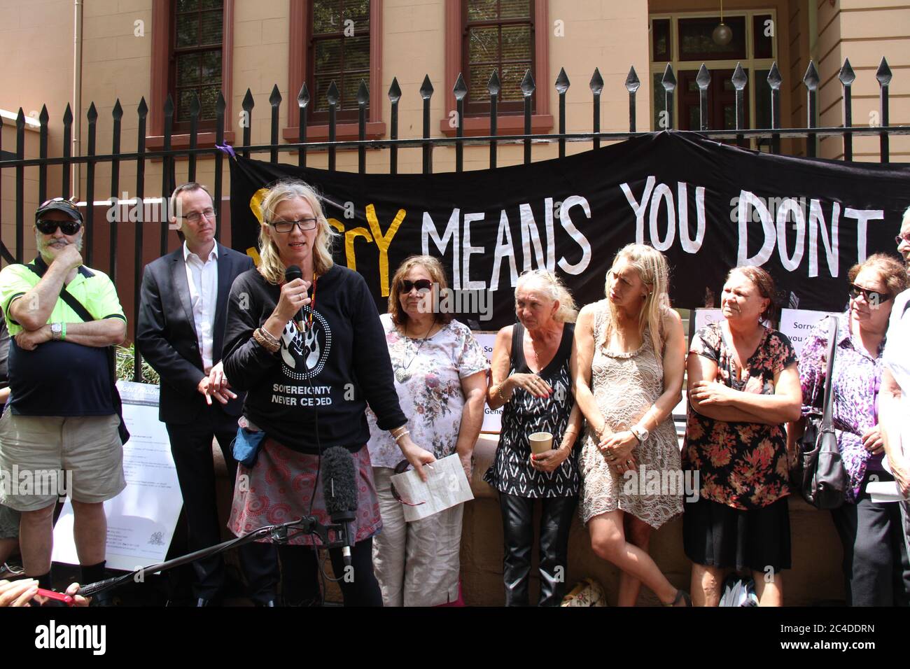 A banner at the rally says, ‘Sorry means you don’t do it again’ Stock ...