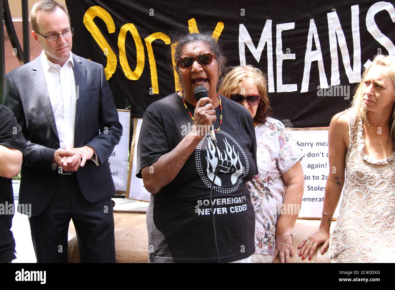 A banner at the rally says, ‘Sorry means you don’t do it again’ Stock ...