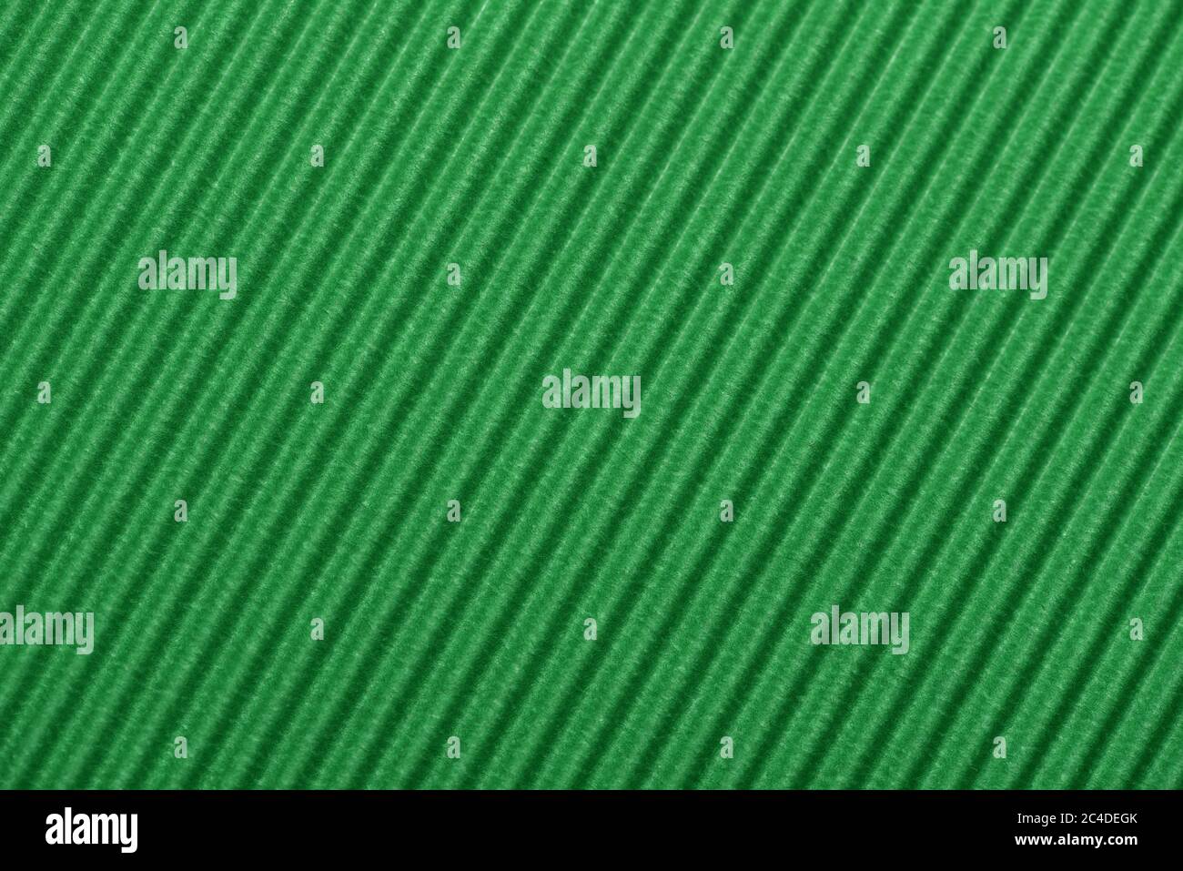 Light green colored corrugated cardboard texture useful as a background Textured corrugated striped cardboard green Stock Photo