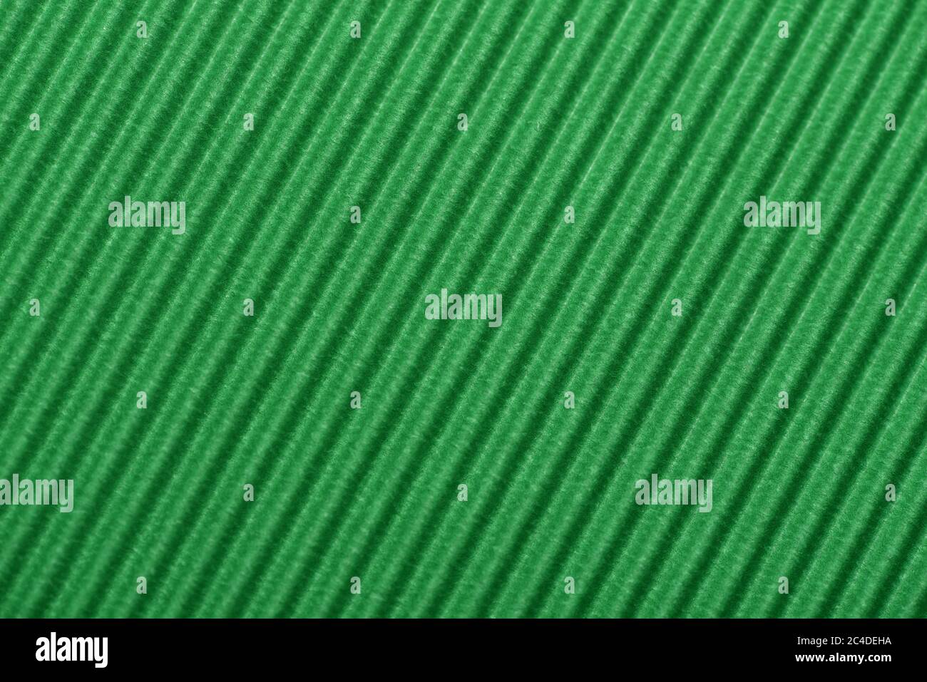 Light green colored corrugated cardboard texture useful as a background Textured corrugated striped cardboard green Stock Photo