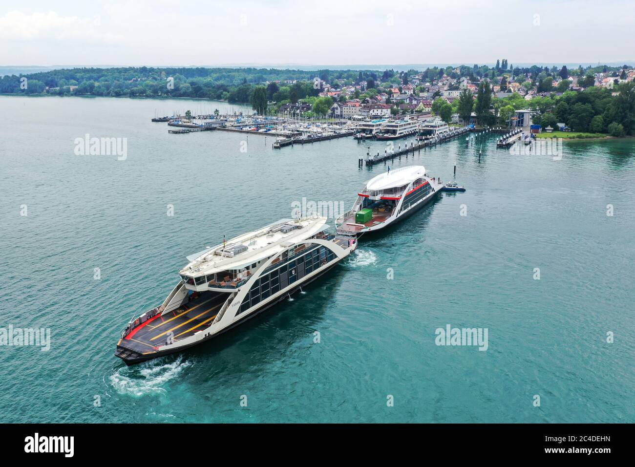 Konstanz, Germany. 26th June, 2020. The shell of a new ferry is being manoeuvred into the ferry port from another ferry on Lake Constance (shot with drone). For the first time the ferry has a new paint scheme. Instead of blue and white like the old ferries, the new ferry is now red-white. Credit: Felix Kästle/dpa/Alamy Live News Stock Photo
