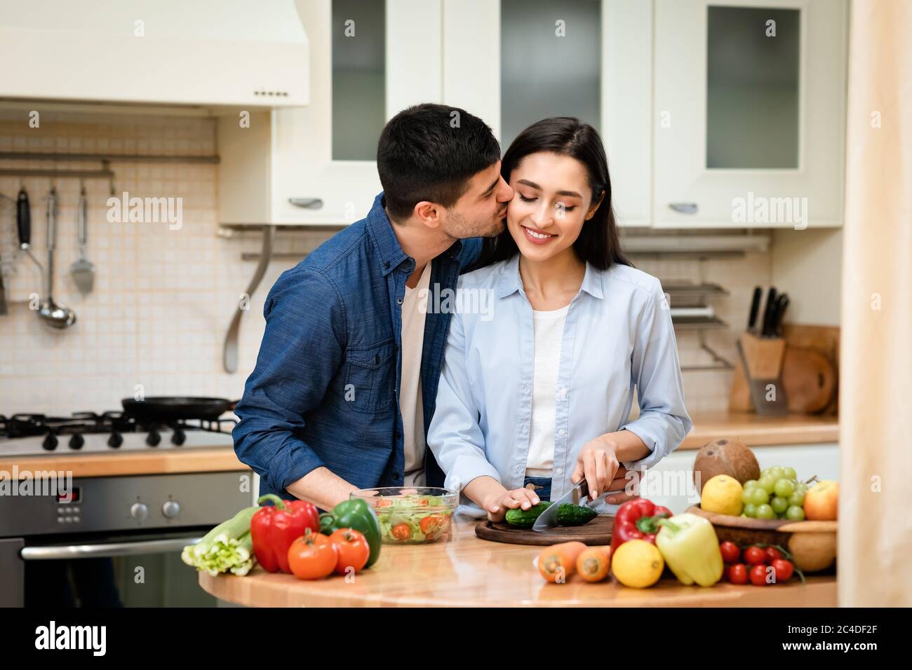 Lovely couple preparing dinner cutting vegetables at home Stock Photo