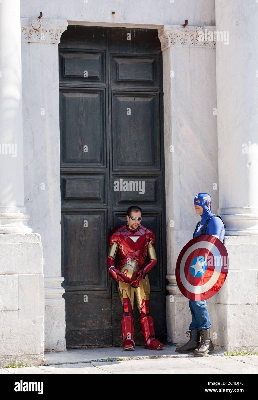 LUCCA, ITALY - OCTOBER 29, 2011: Captain America and Iron Man standing in front of the Cathedral's gate during the Lucca comics and games annual festi Stock Photo