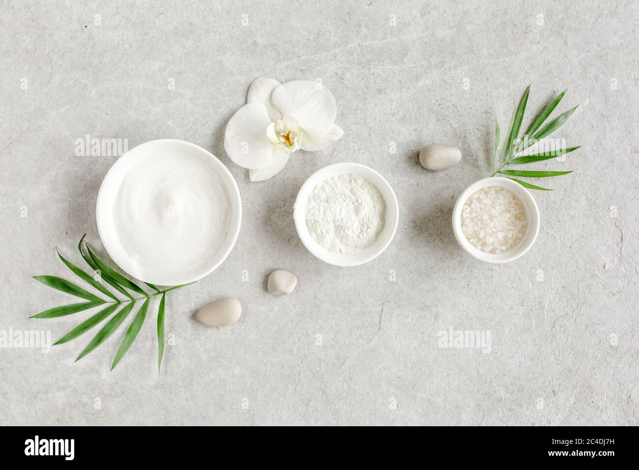 Female skin and body care cosmetic products set: facial cream, cosmetic clay, sea salt on gray marble background. Beauty blogger, salon treatments  Stock Photo