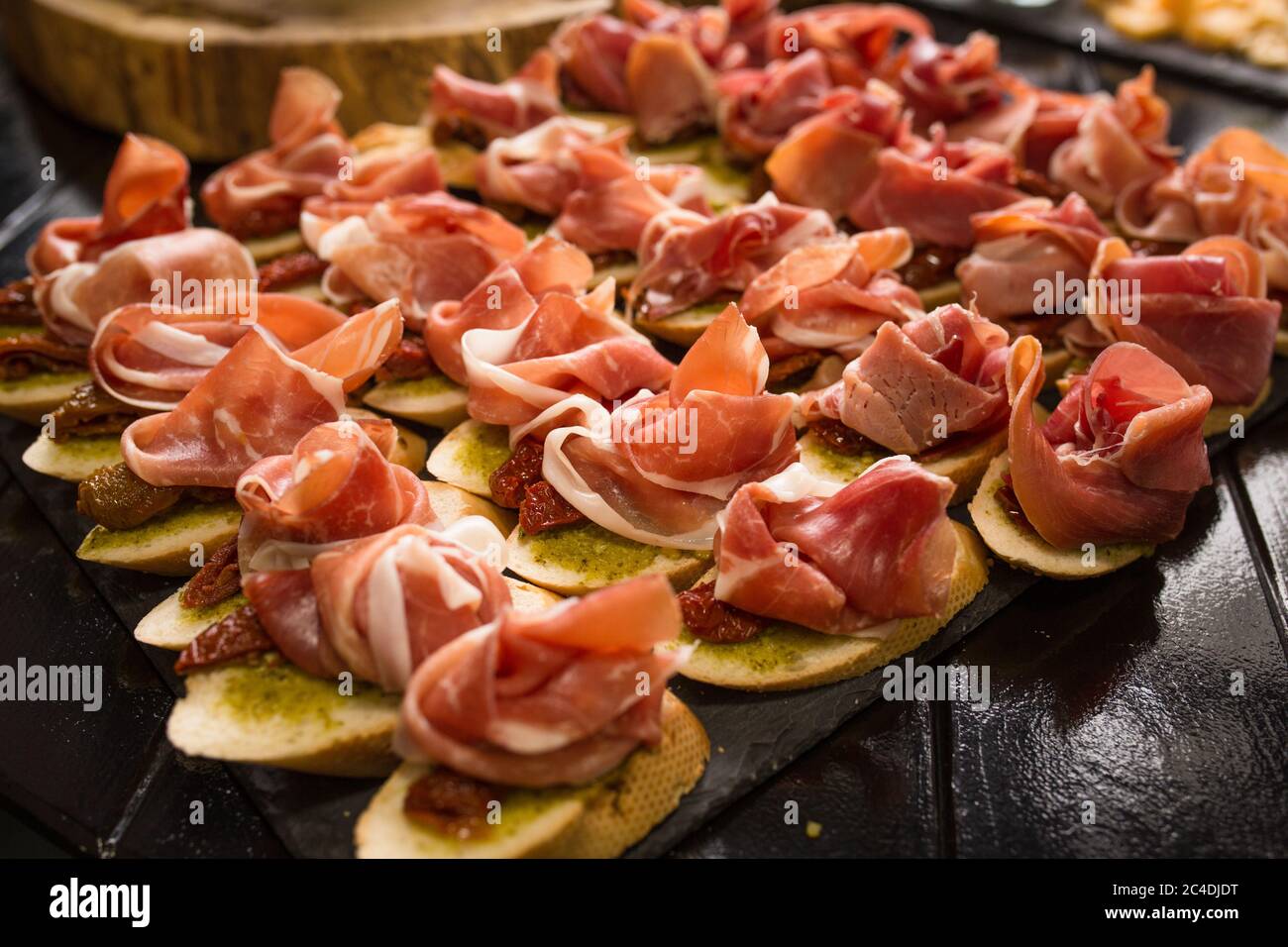 Bruschettas with ham or parma. Snack baguette with meat. Antipasto concept. Catering food concept. Close up shot Stock Photo