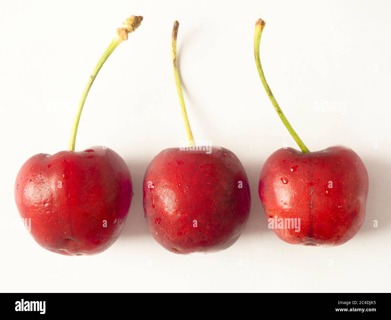 Three fresh ripe cherries isoalted on a white background Stock Photo